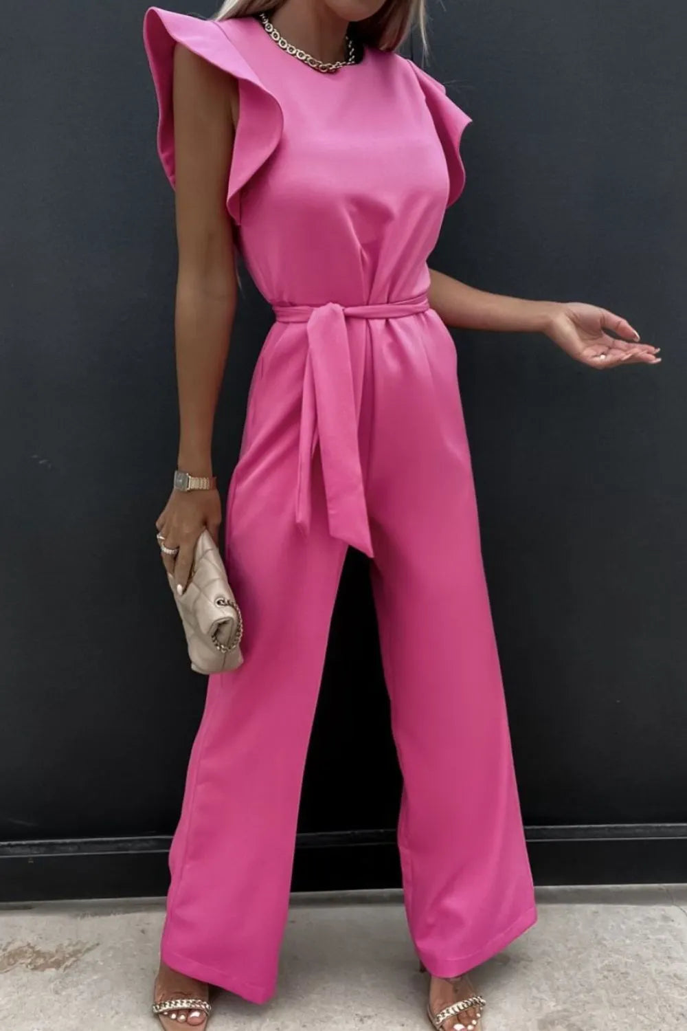 Pink round-neck cap sleeve jumpsuit with ruffled shoulder caps and tied waist