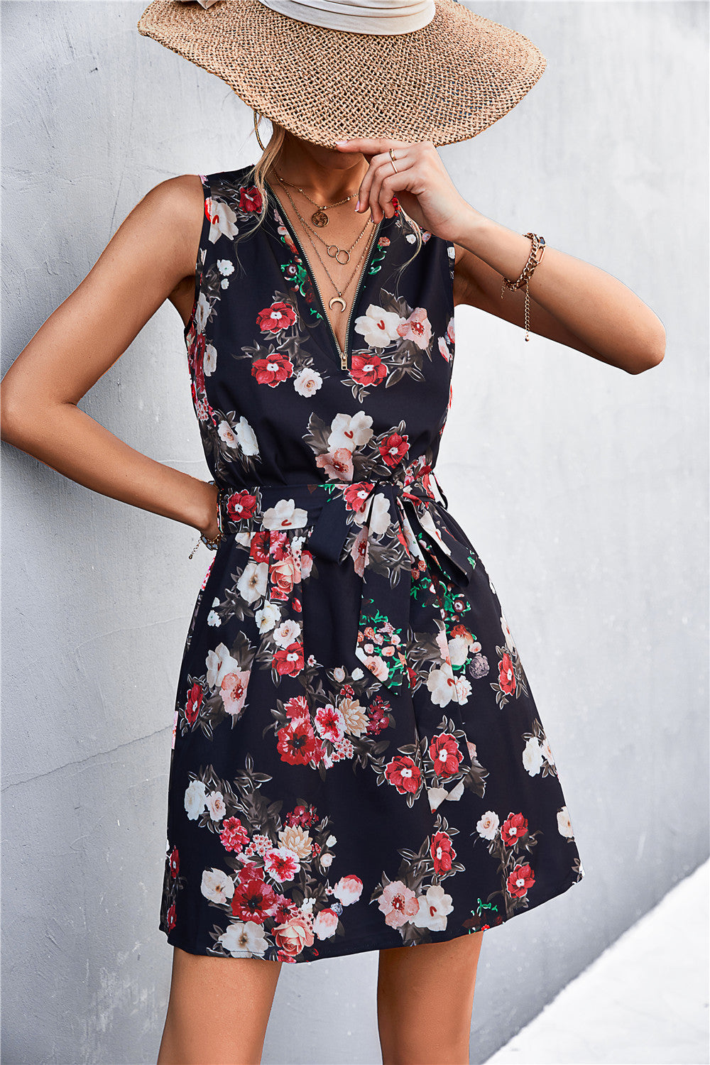 Dark floral sleeveless dress with V-neck and tie waist, front zip detail