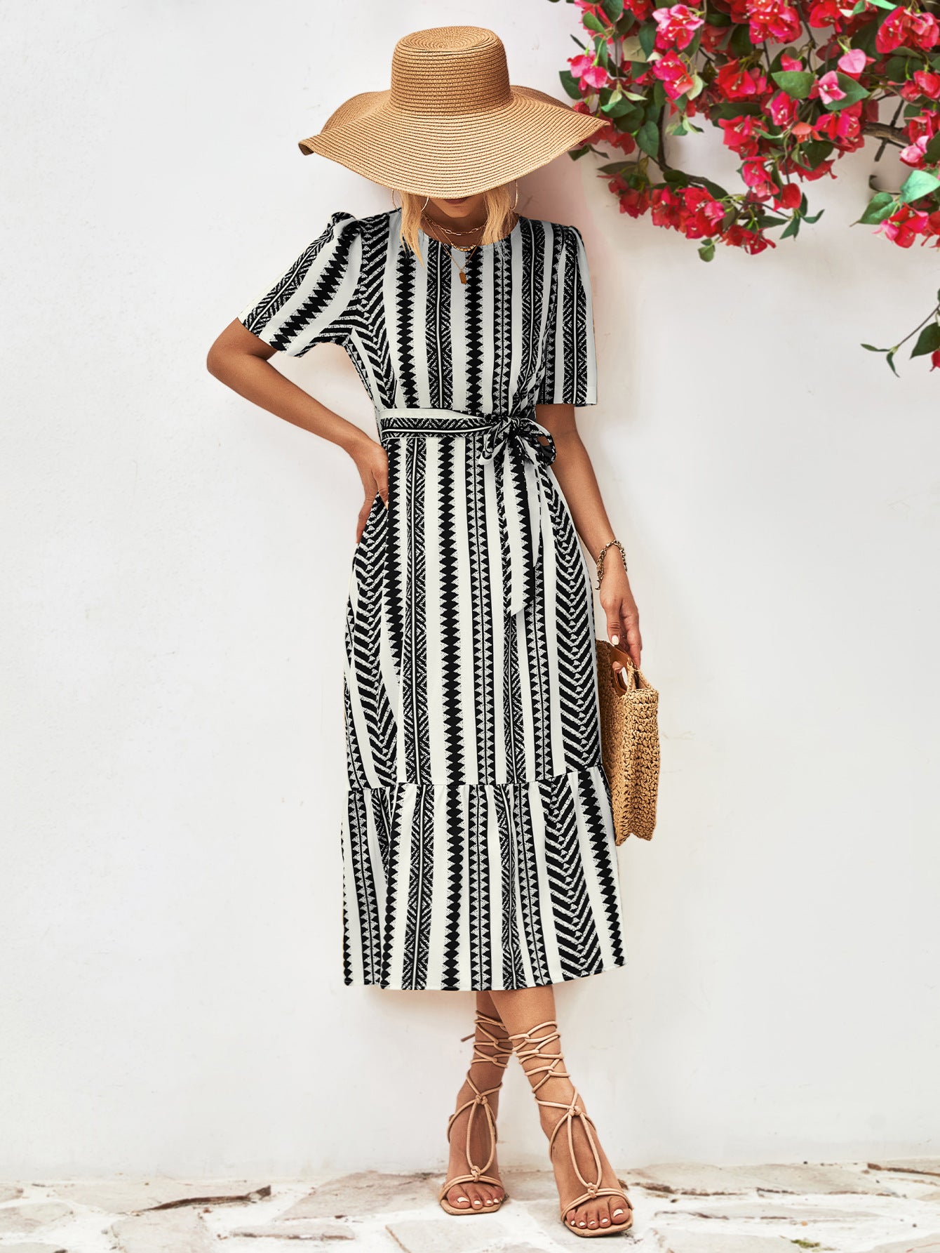 Black striped round-neck puff sleeve dress with tied waist belt, front view with purse.