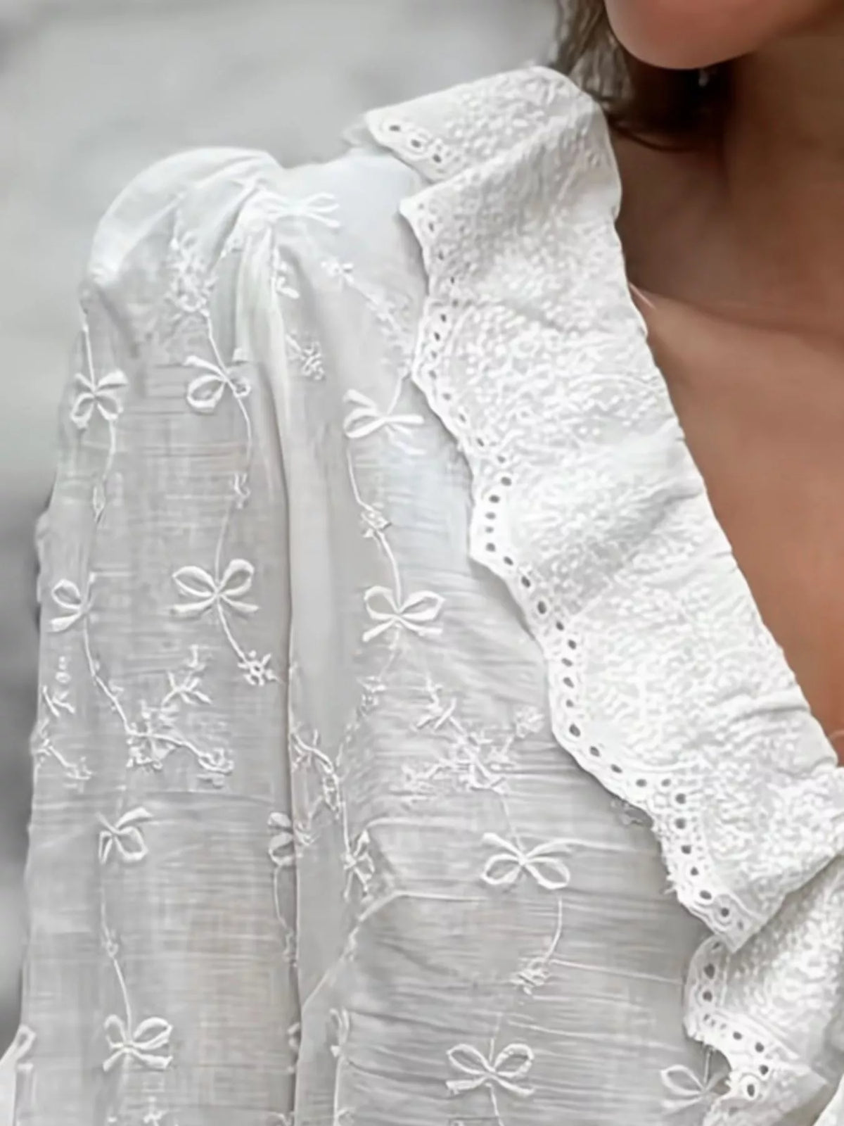 White embroidered blouse with sheer puff sleeves and ruffled V-neck front