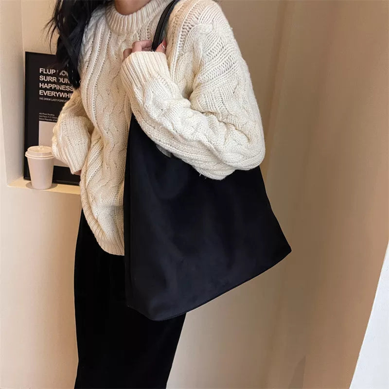 Dark shoulder bag with wide strap and open top