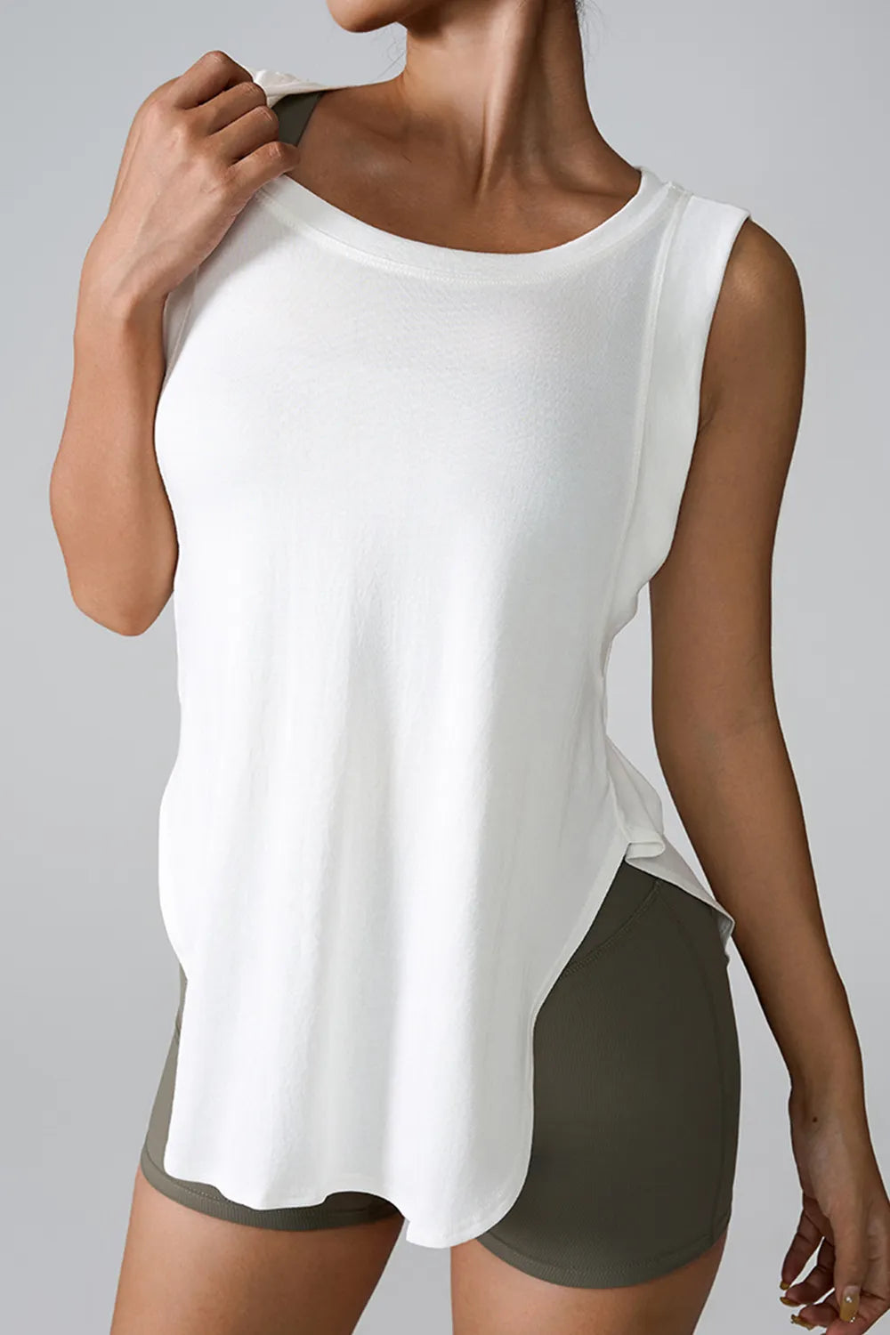 White sleeveless active tank top with round neck and side slit at lower hem
