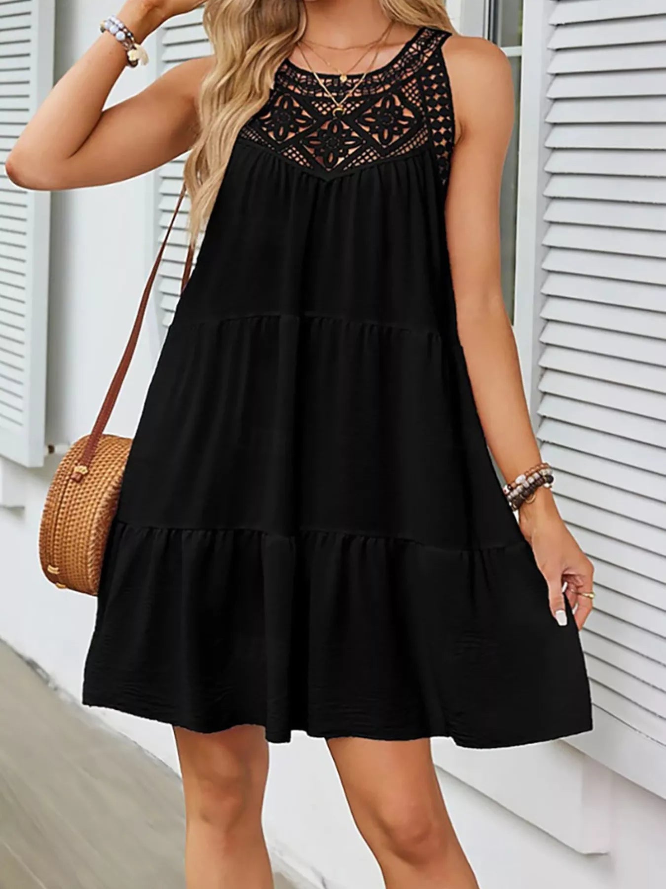 Black sleeveless lace-detail dress with embroidered lace neckline and tiers