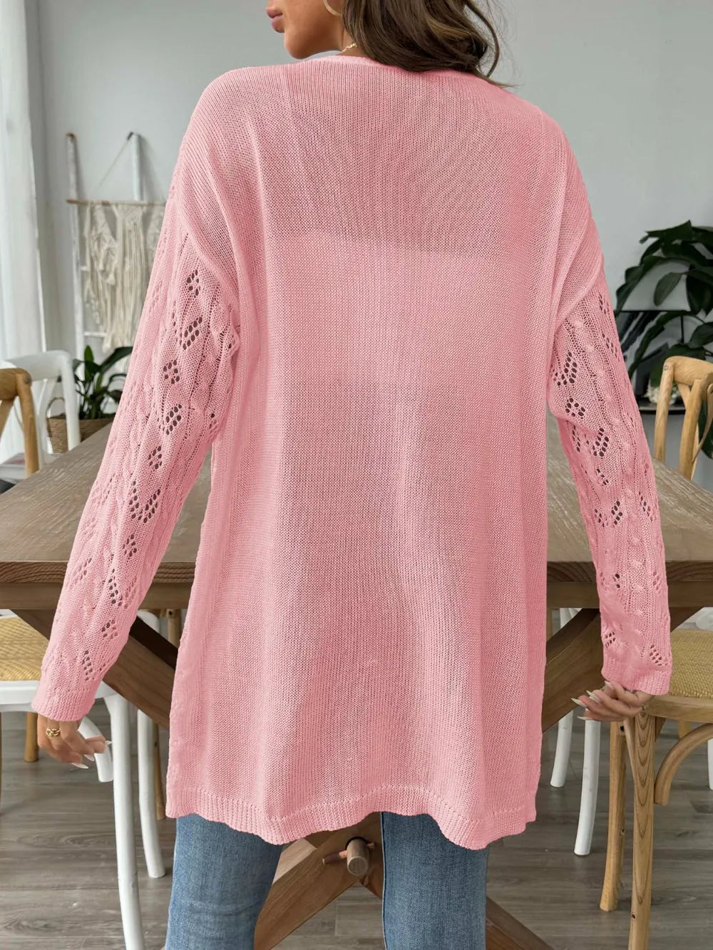 Pink long-sleeve open-front cardigan with openwork lace knit detailing on sleeves.