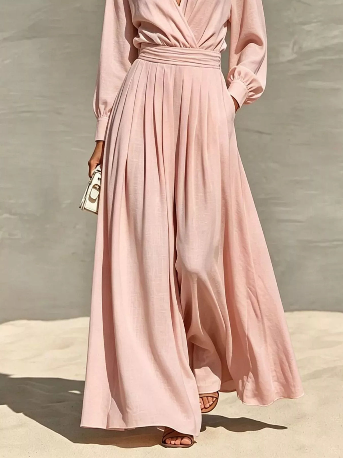 Pale blush wide-leg wrap jumpsuit with pleated flowing legs and long sleeves