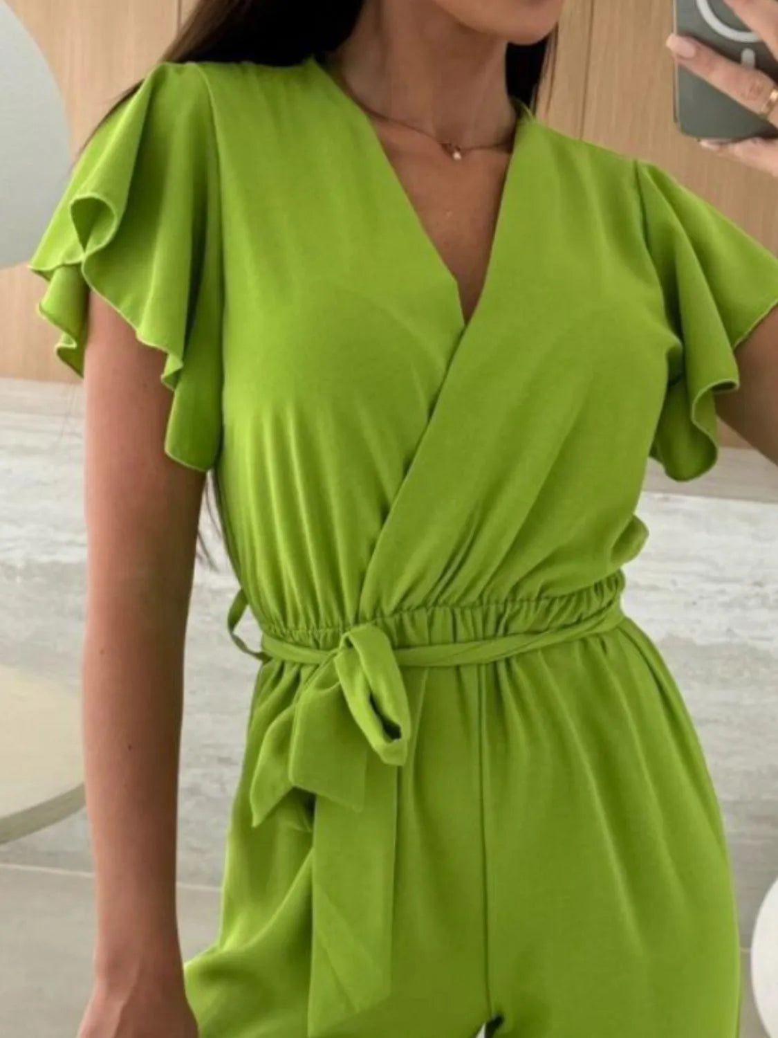 Lime green ruffled V-neck wide-leg jumpsuit with drawstring tie waist