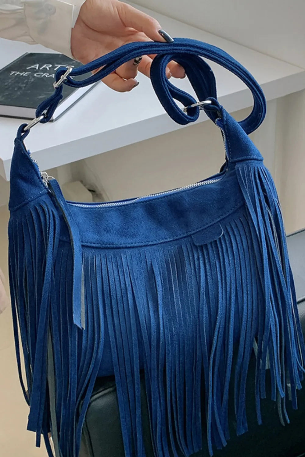 Blue suede fringe shoulder bag with top closure and shoulder strap