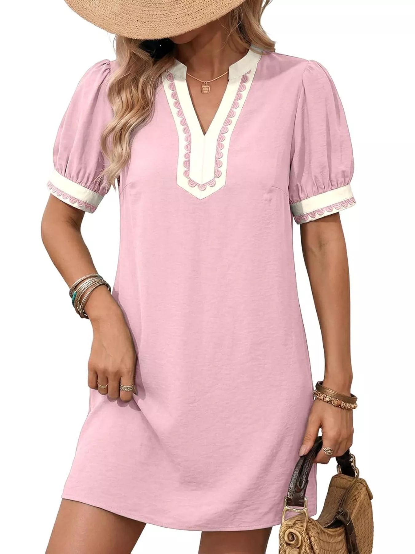 Pink mini dress with notched V neckline and puff sleeves, white trim at collar and cuffs.