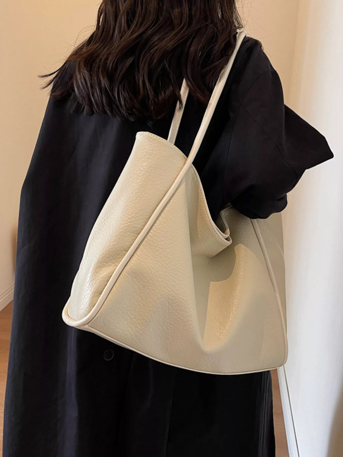 Off-white vegan leather tote bag with long shoulder straps and open top