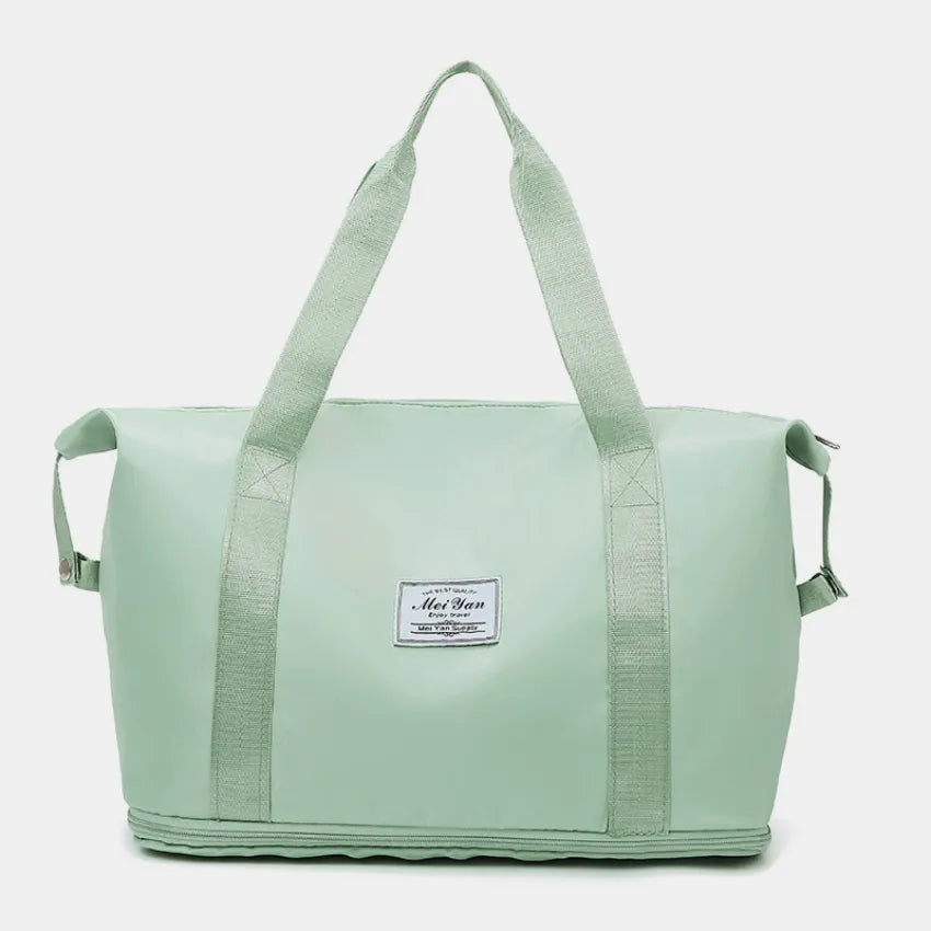 Mint green large duffle bag with long handles and front patch label