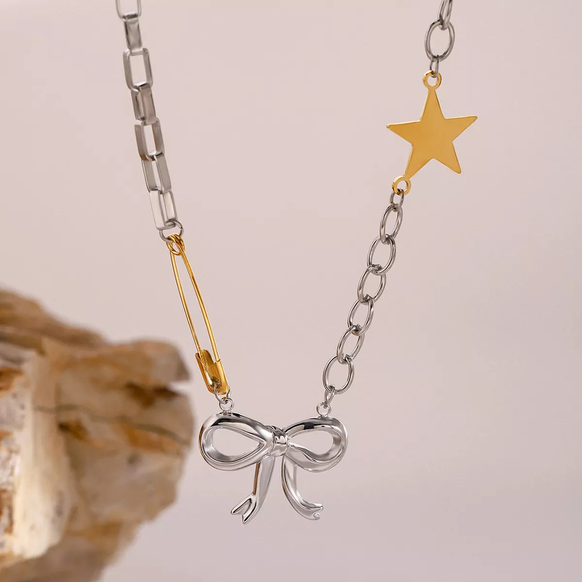 Two-tone star bow necklace: gold star and ribbon bow pendant on silver chain with gold bar