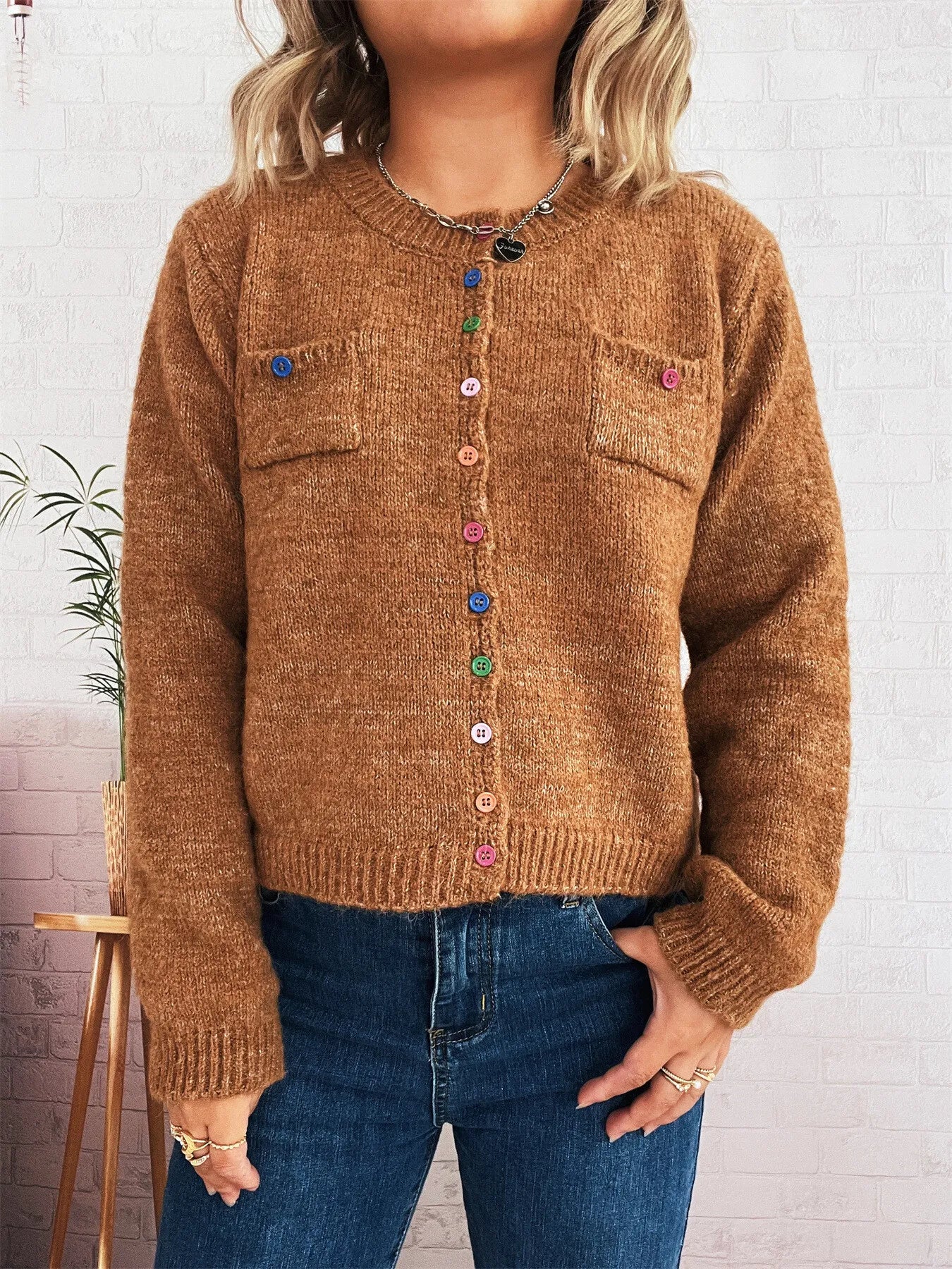 Brown knit cardigan with button front, chest pockets, and ribbed cuffs and hem