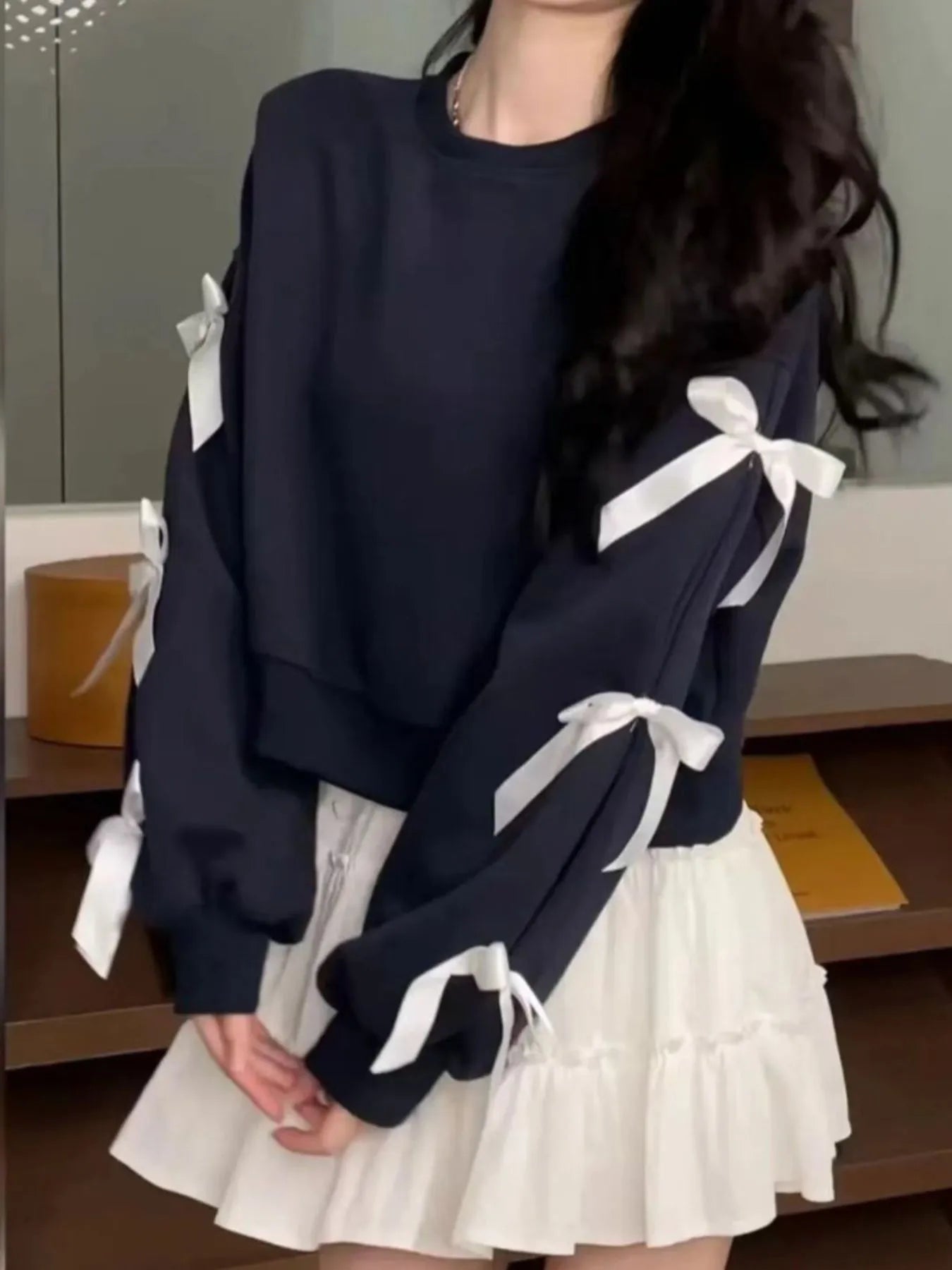 Dark blue round-neck sweatshirt with white bow ties on sleeves