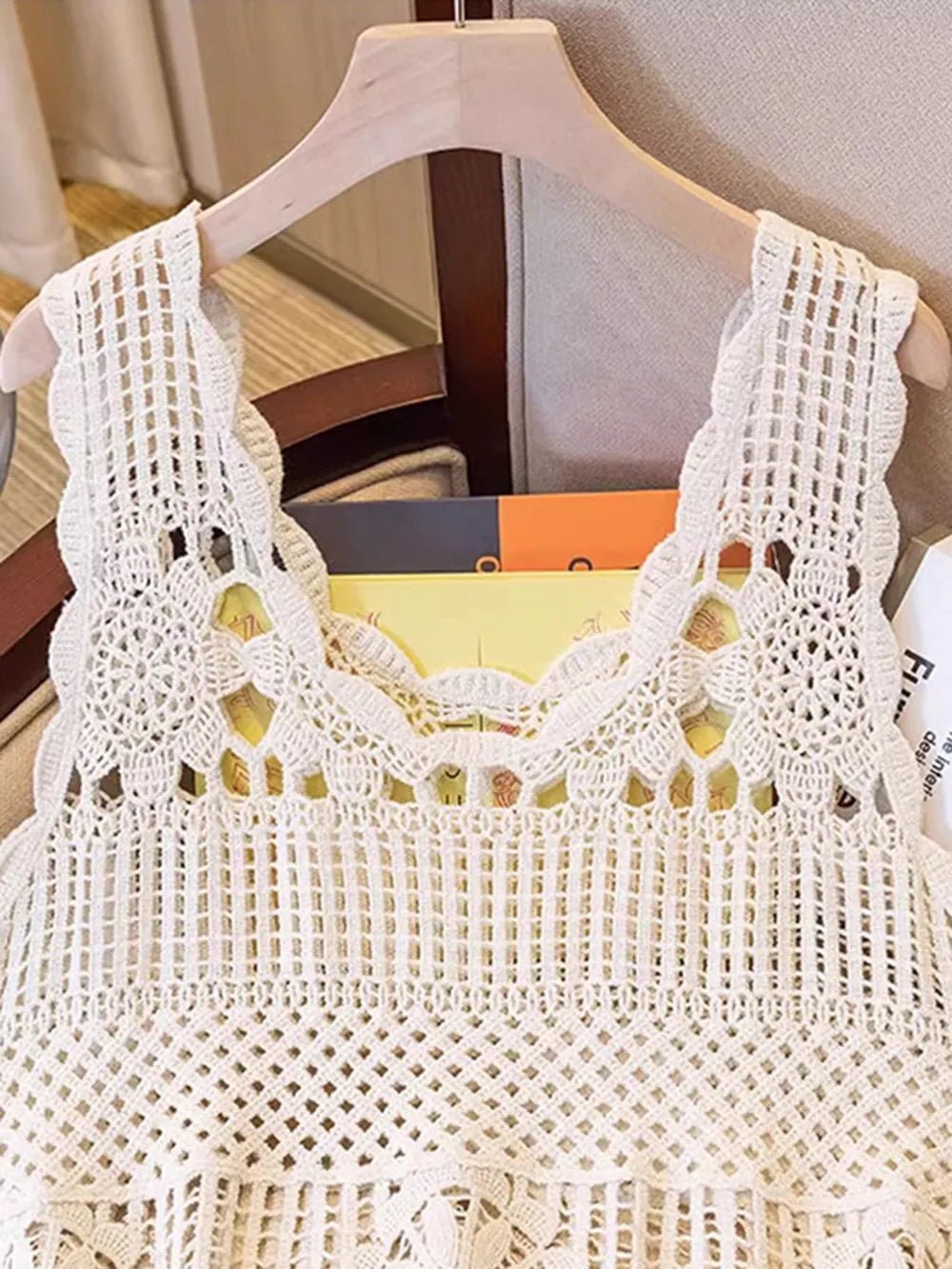 Cream openwork scoop-neck tank on hanger with lace-like crochet yoke and wide straps