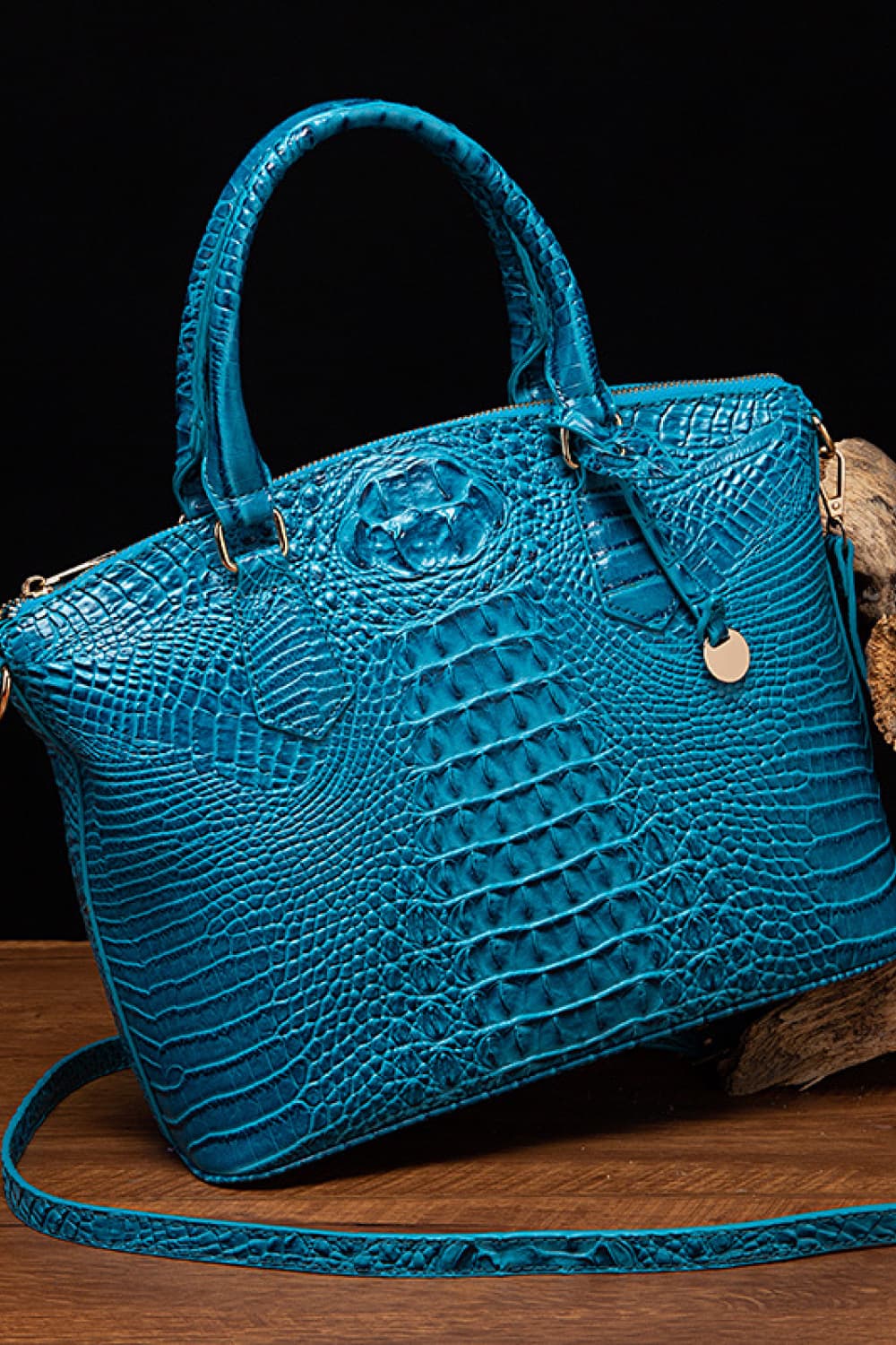Croc-embossed vegan leather handbag in bright blue with top handles and front emblem