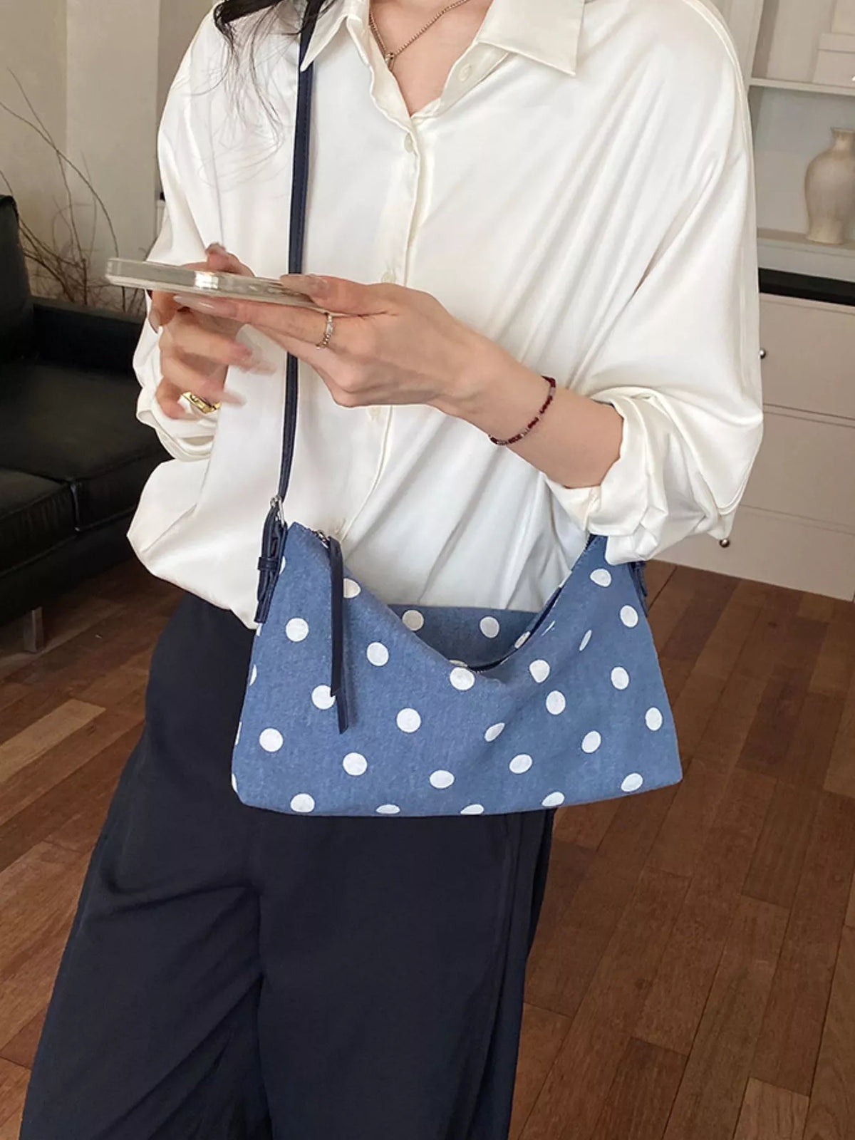 Small blue polka dot shoulder bag with zipper top worn crossbody