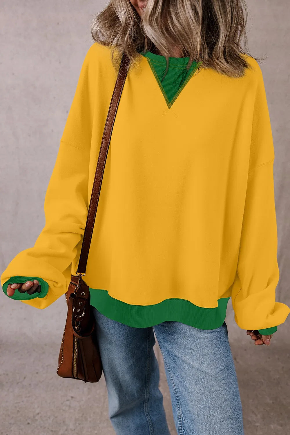 Yellow long-sleeve sweatshirt with green contrast round neckline, hem, and cuffs