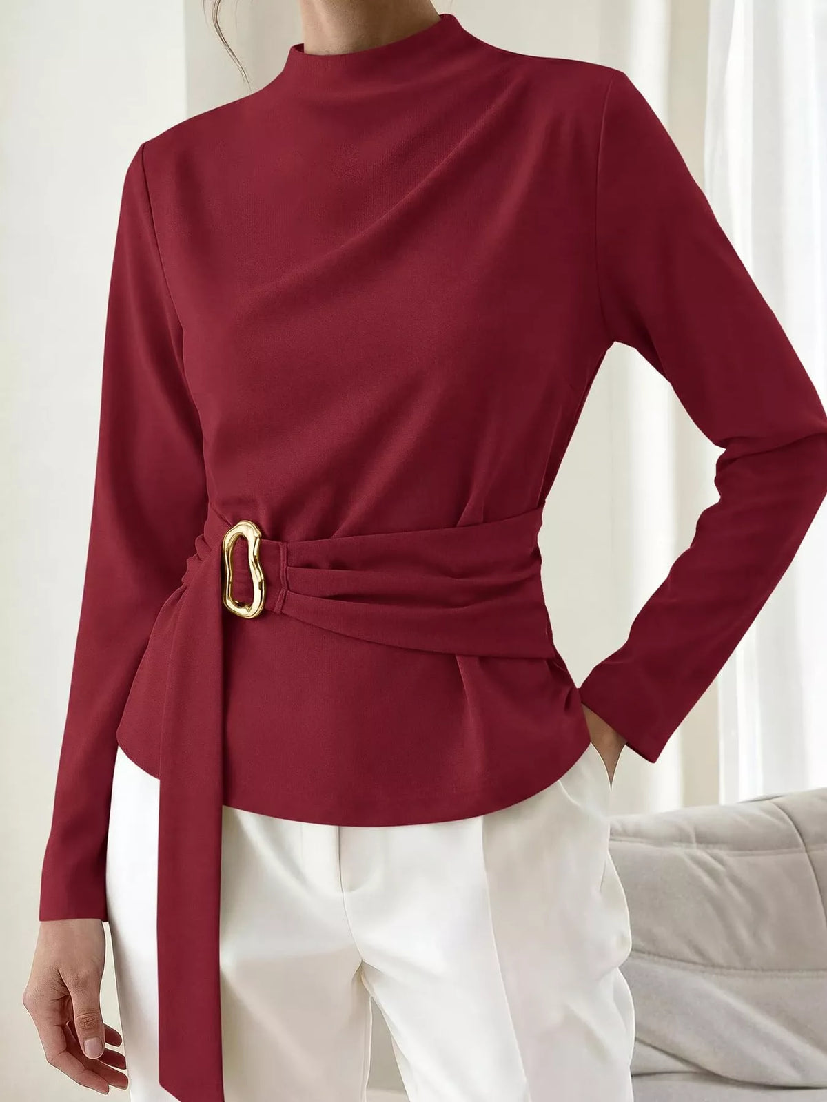 Burgundy mock neck blouse with ruched waist belt and gold ring detail; long sleeves