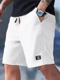 Waffle knit drawstring casual shorts in white, side view with logo patch