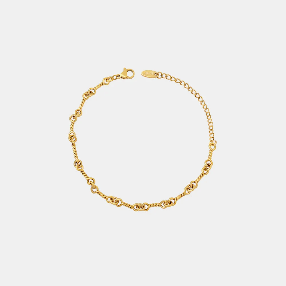 Gold link chain bracelet with oval toggle clasp and small engraved tag