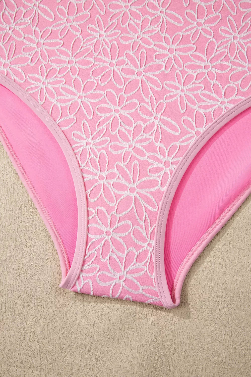 Blush pink floral one-piece swimsuit bottom close-up with high-cut leg opening