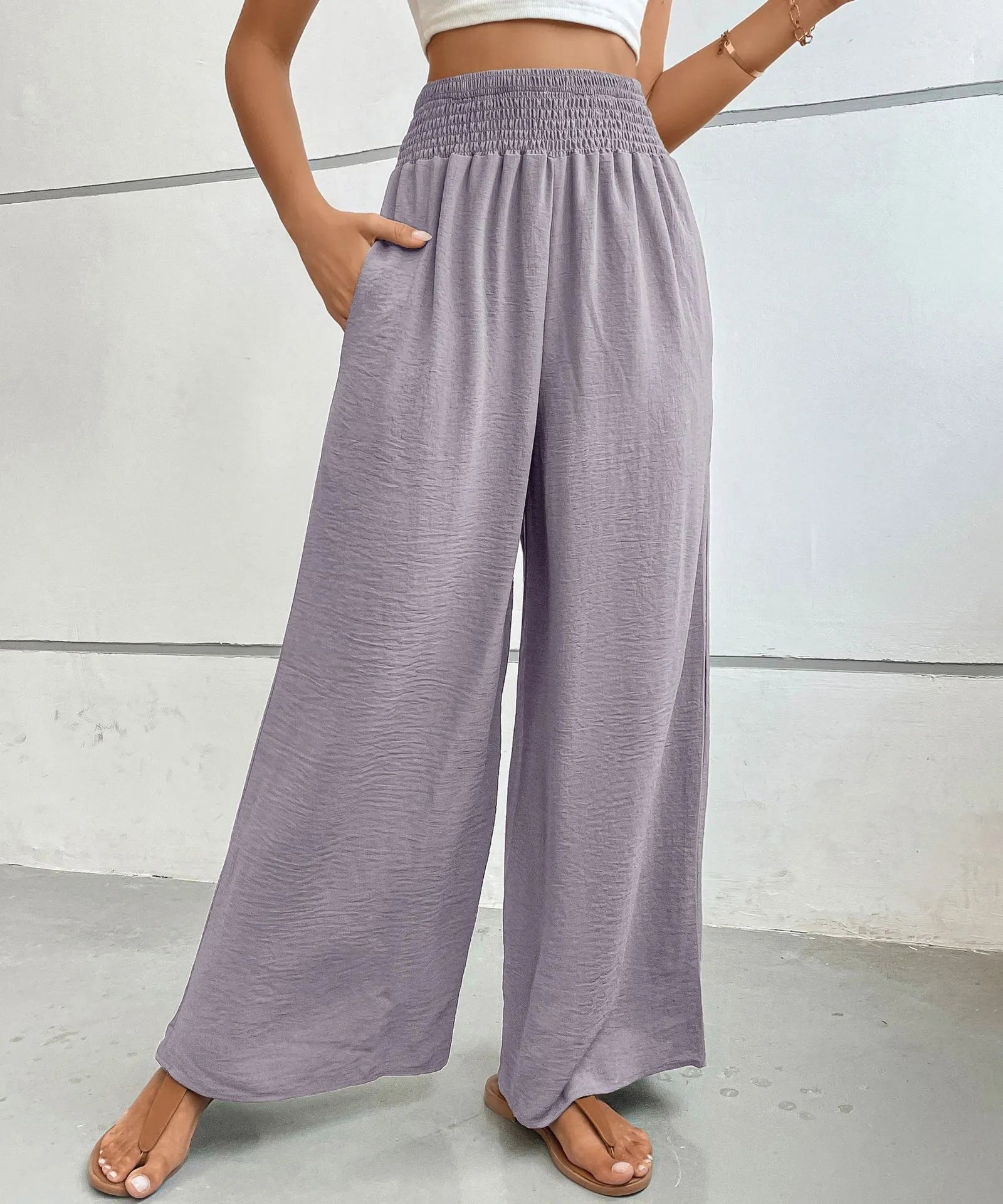 High-waisted wide-leg pants in lilac with elastic smocked waistband and loose wide-leg fit.