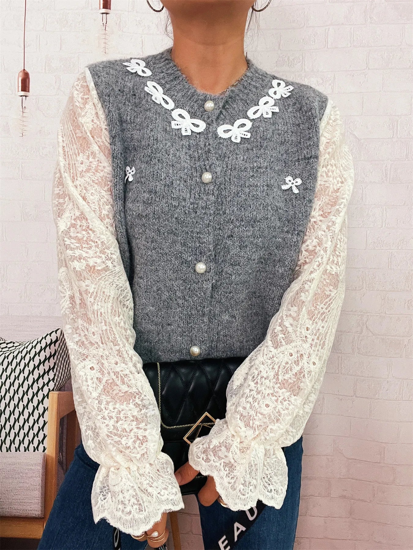 Gray knit button-up cardigan with lace sleeves, bow trim, and pearl-style front buttons