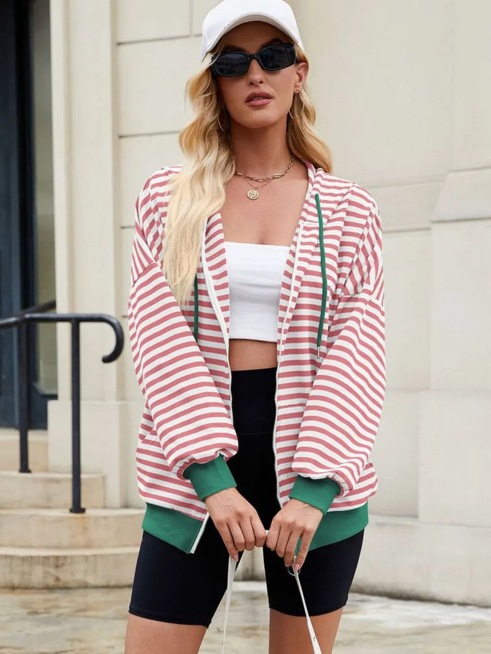 Pink-and-white striped zip-up hoodie with hood and drawstring, long sleeves.