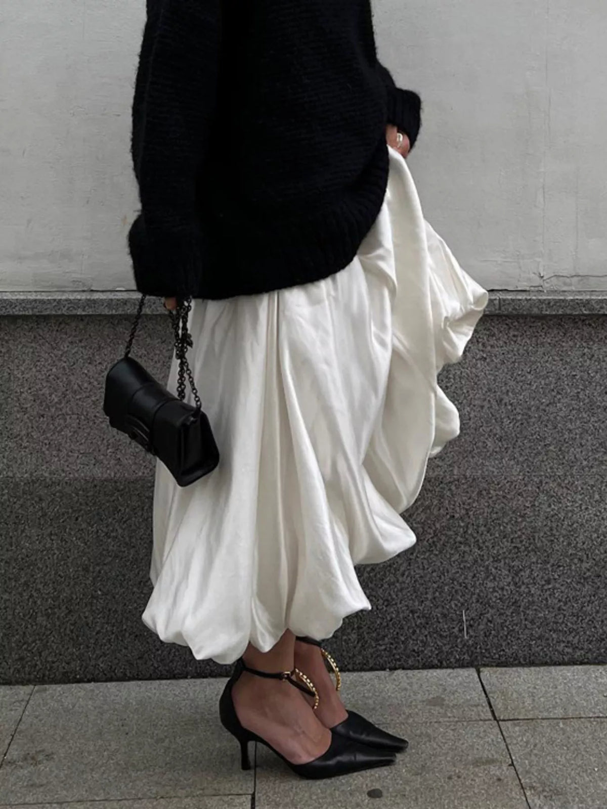 White satin maxi skirt with back zipper and pleated, flowing silhouette