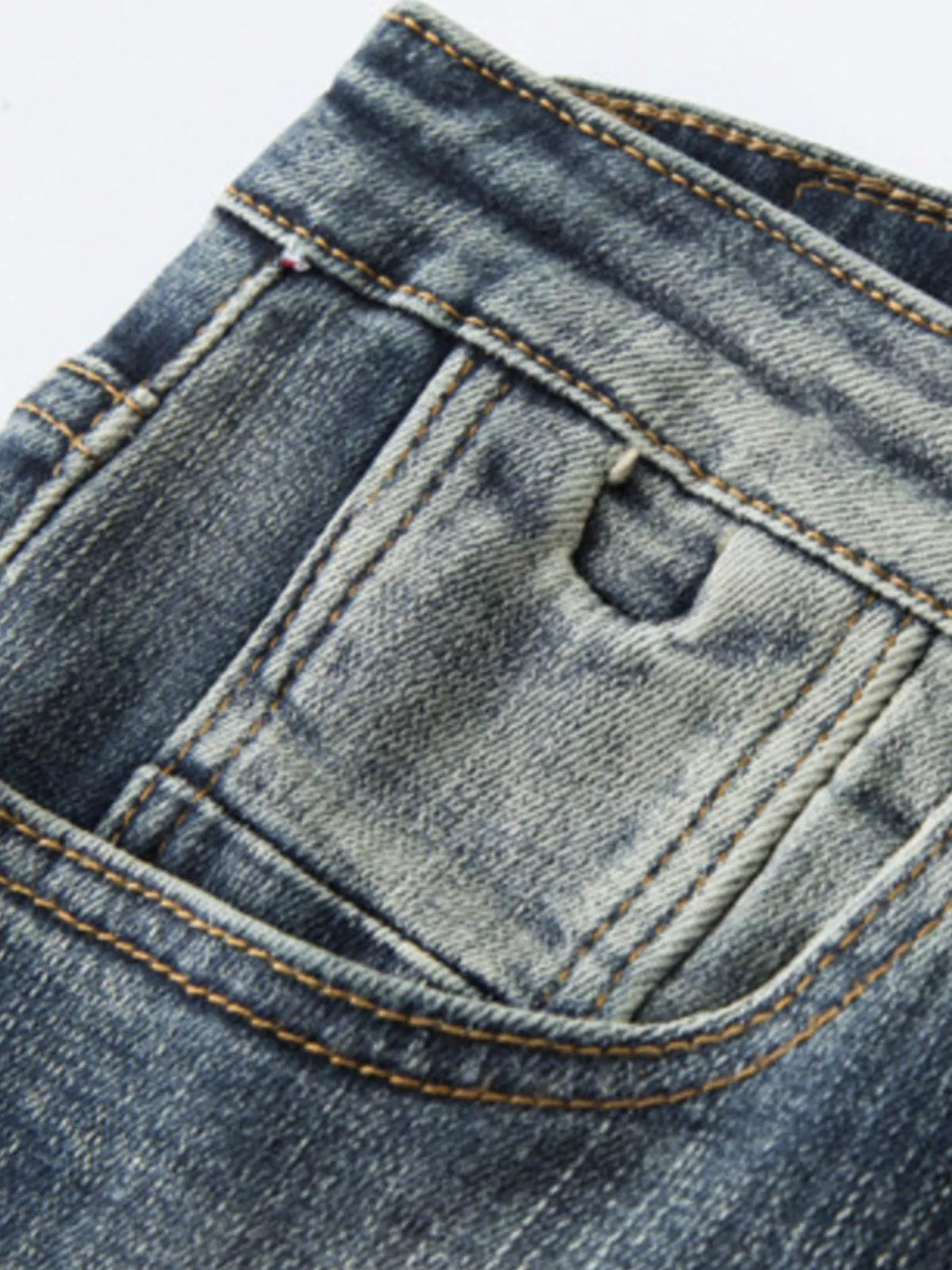 Denim jeans pocket close-up with contrast stitching and vintage wash texture