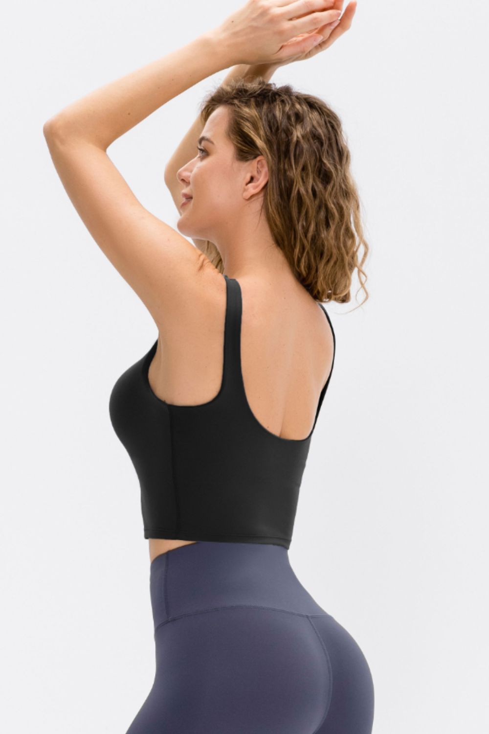 Cropped scoop neck active tank top, black; side view with racerback and cropped fit.