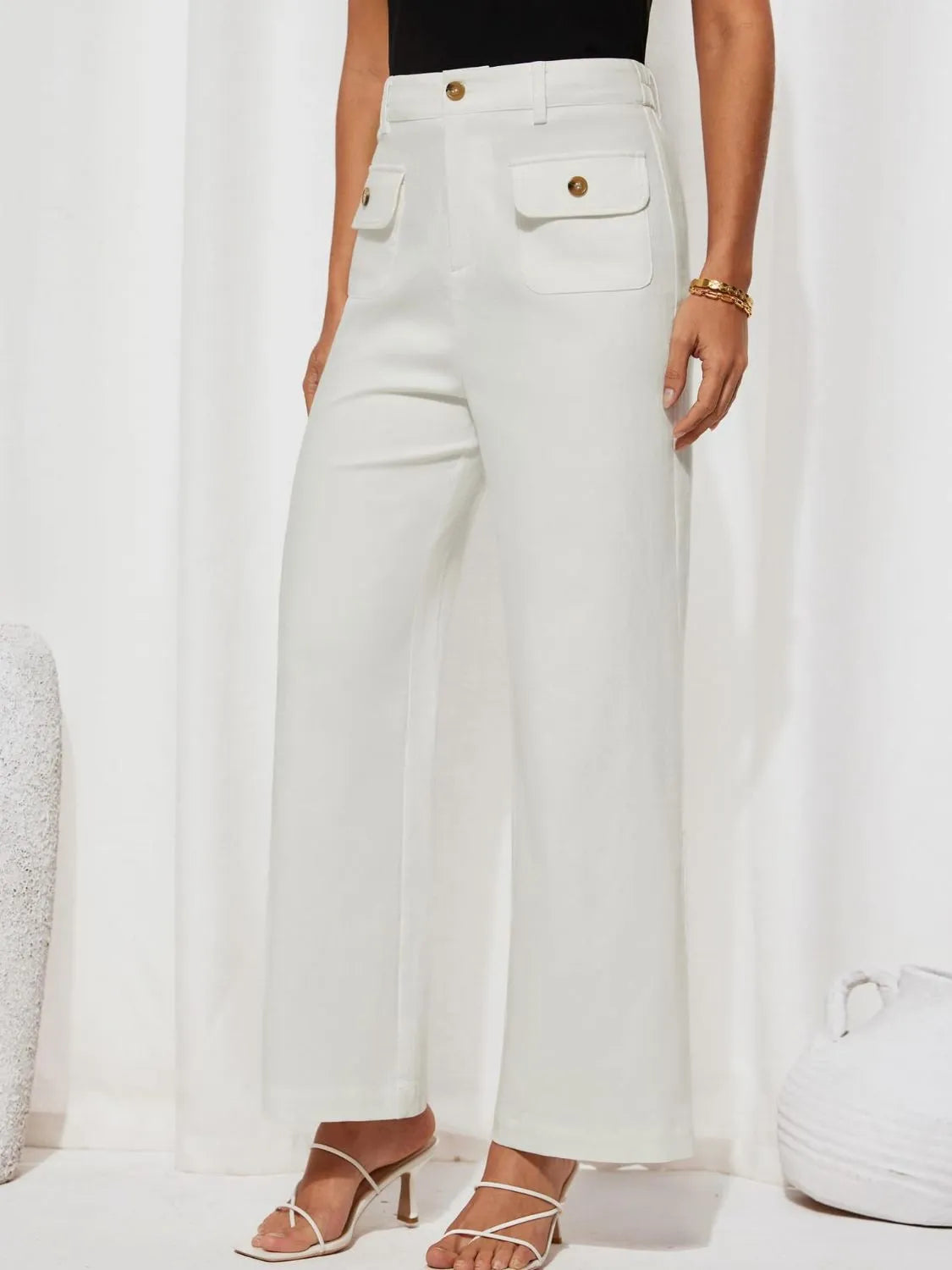White high-waist wide-leg pants with front patch pockets and gold button accents