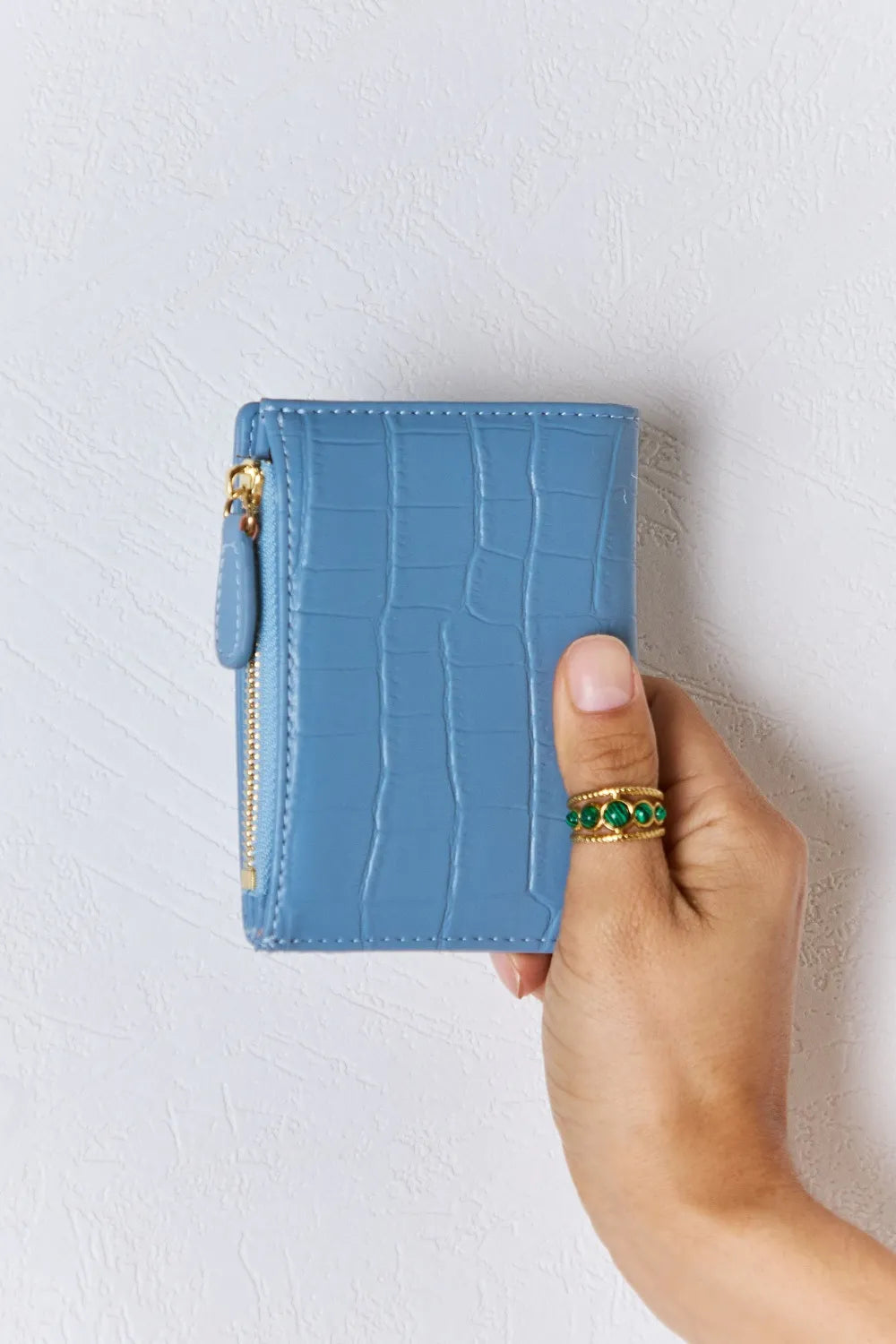 Blue textured vegan leather mini wallet, front view with gold zipper pull and snap button.