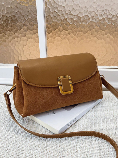 Brown flap crossbody bag with buckle closure and adjustable shoulder strap