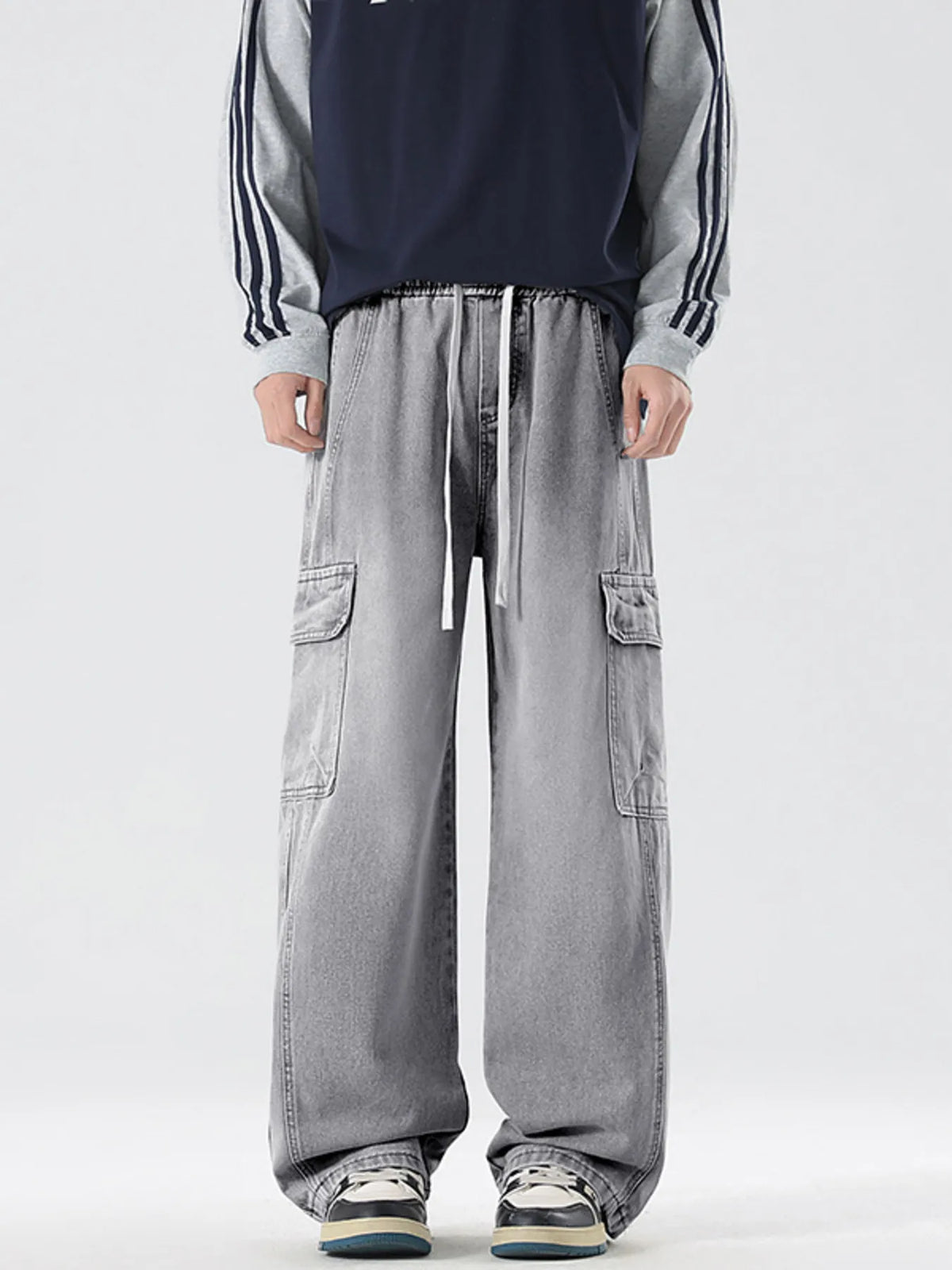 Washed light gray wide-leg cargo jeans with side cargo pockets and long drawcord ties