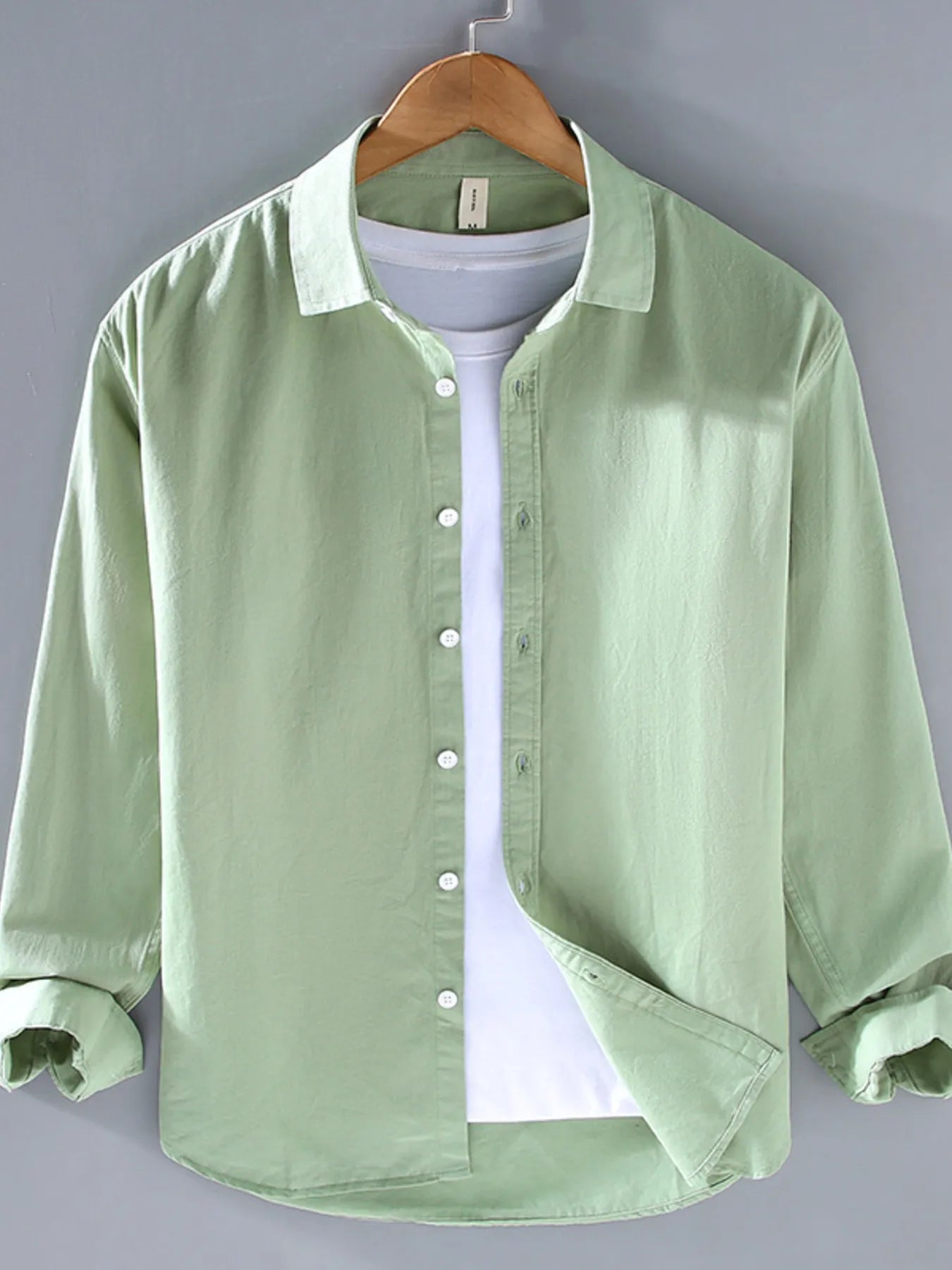 Light green button-up long sleeve shirt with pointed collar and front button placket.