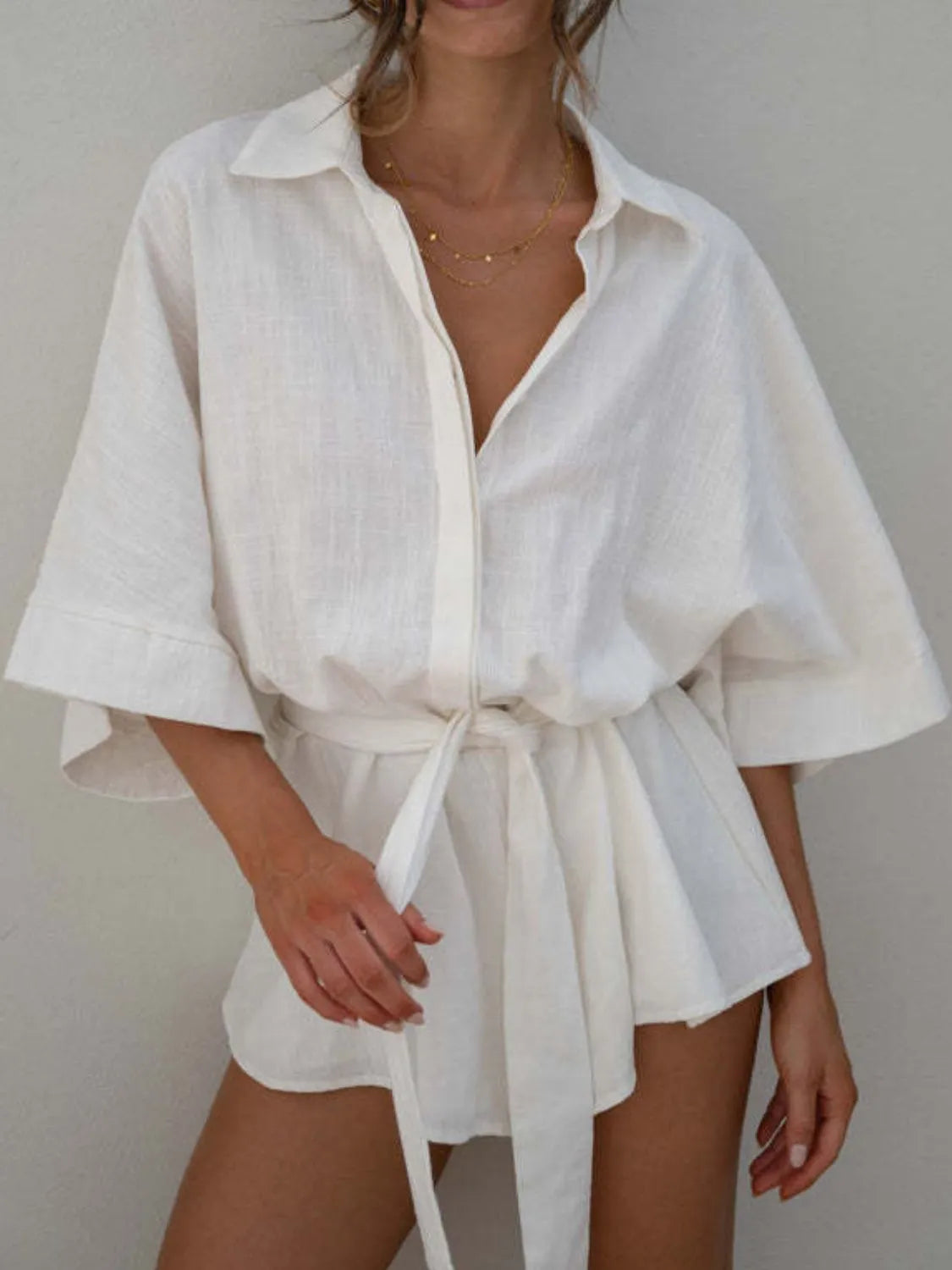 White collared half-sleeve romper with button front and tied waist