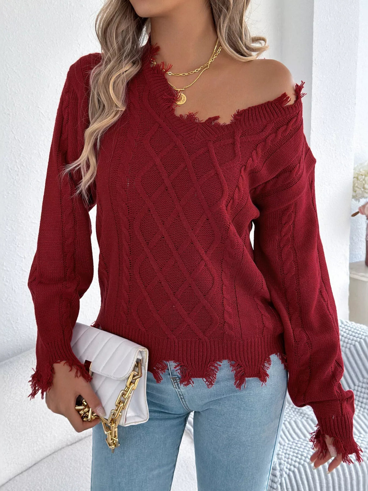 Burgundy V-neck cable knit sweater with distressed raw hem and frayed cuffs