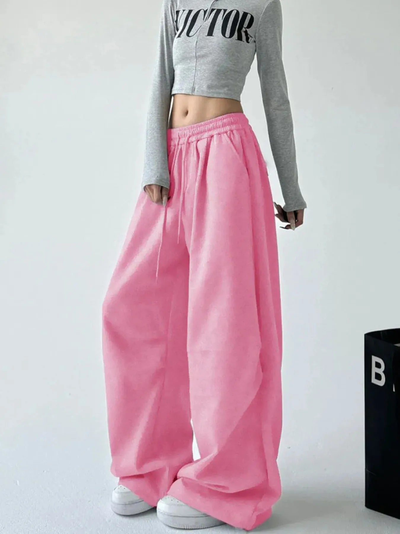 Pink oversized wide-leg drawstring pants with elastic waistband and side pockets
