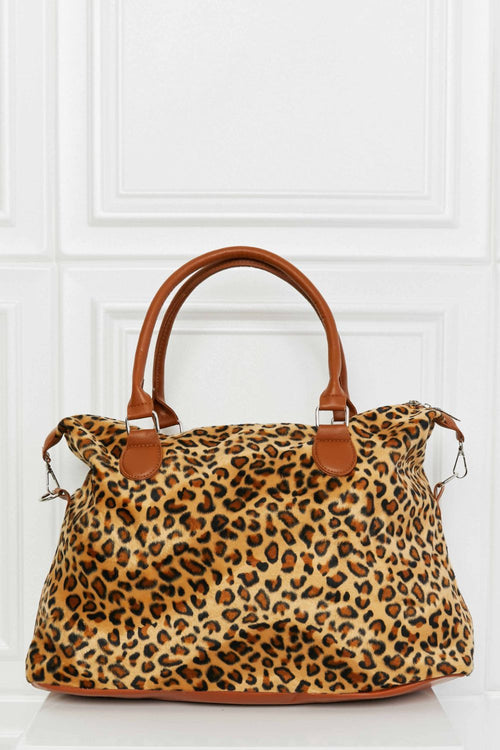 Leopard print weekender bag with tan top handles, side buckles, and zipper