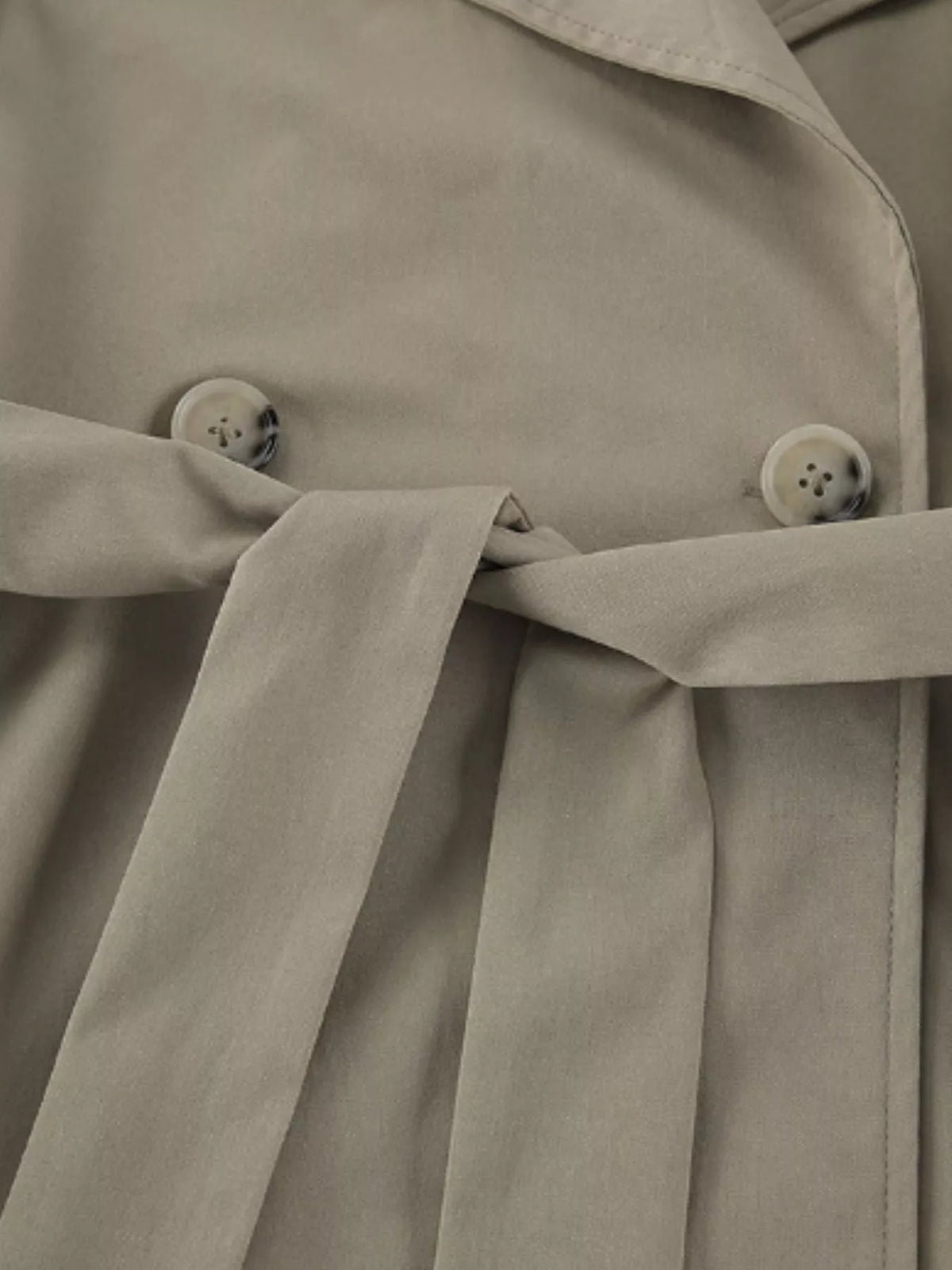 Khaki trench coat belted waist with buttoned front and layered tie straps