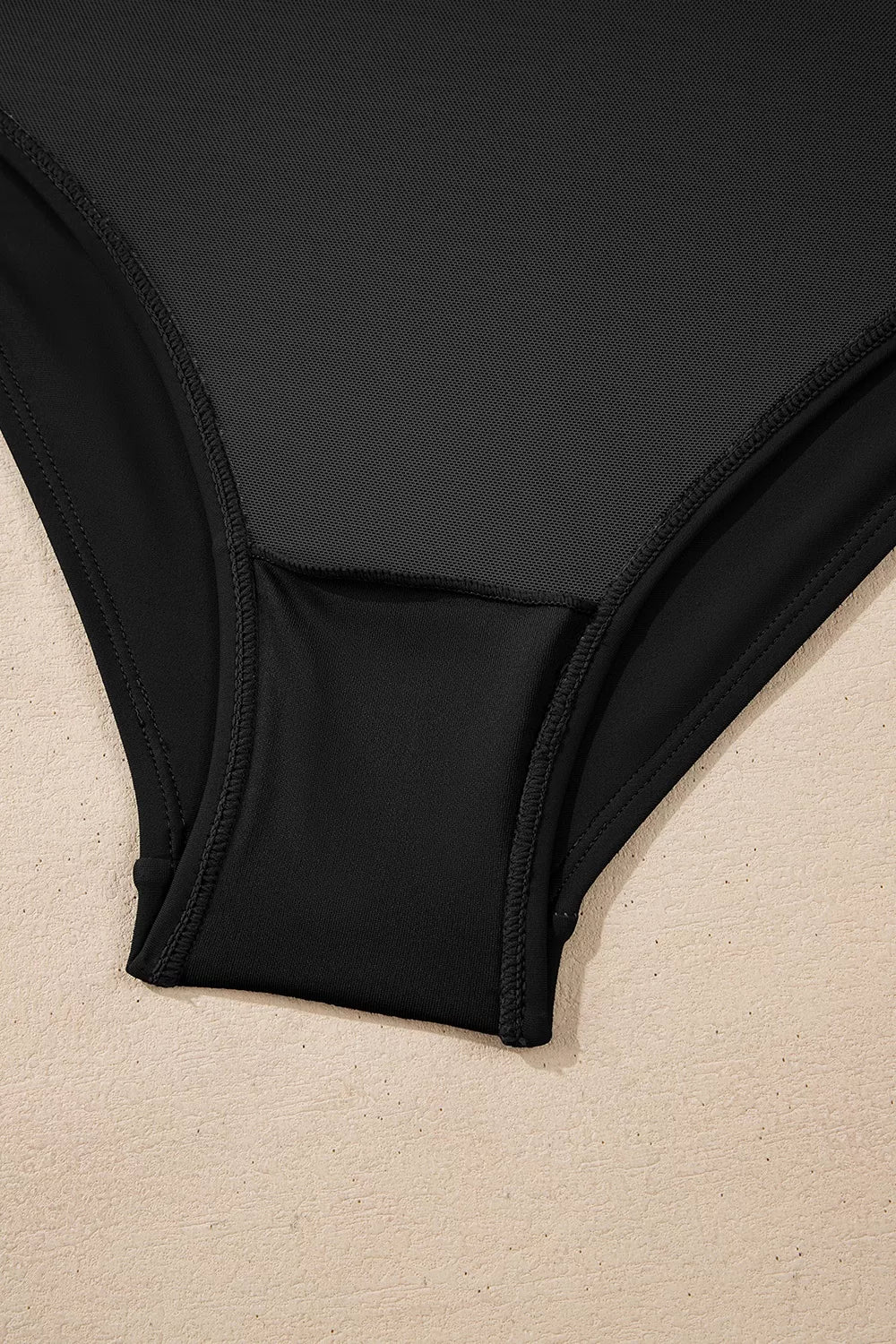 Black one-piece swimsuit hip seam detail with smooth leg opening