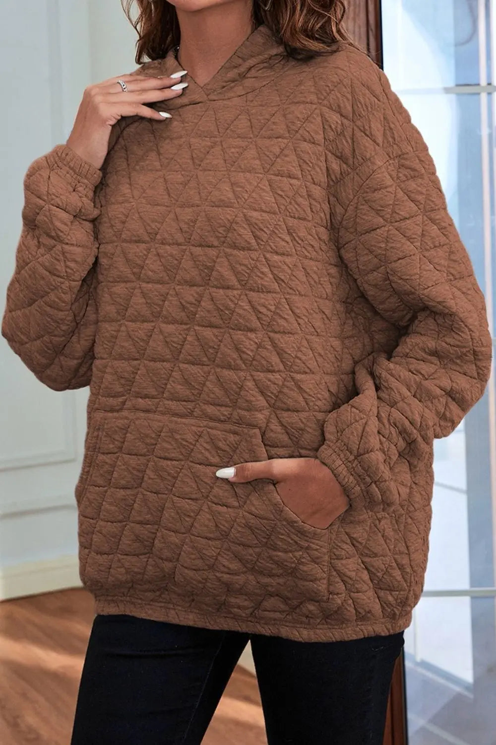 Brown quilted long-sleeve hoodie with hood and front pocket, front view