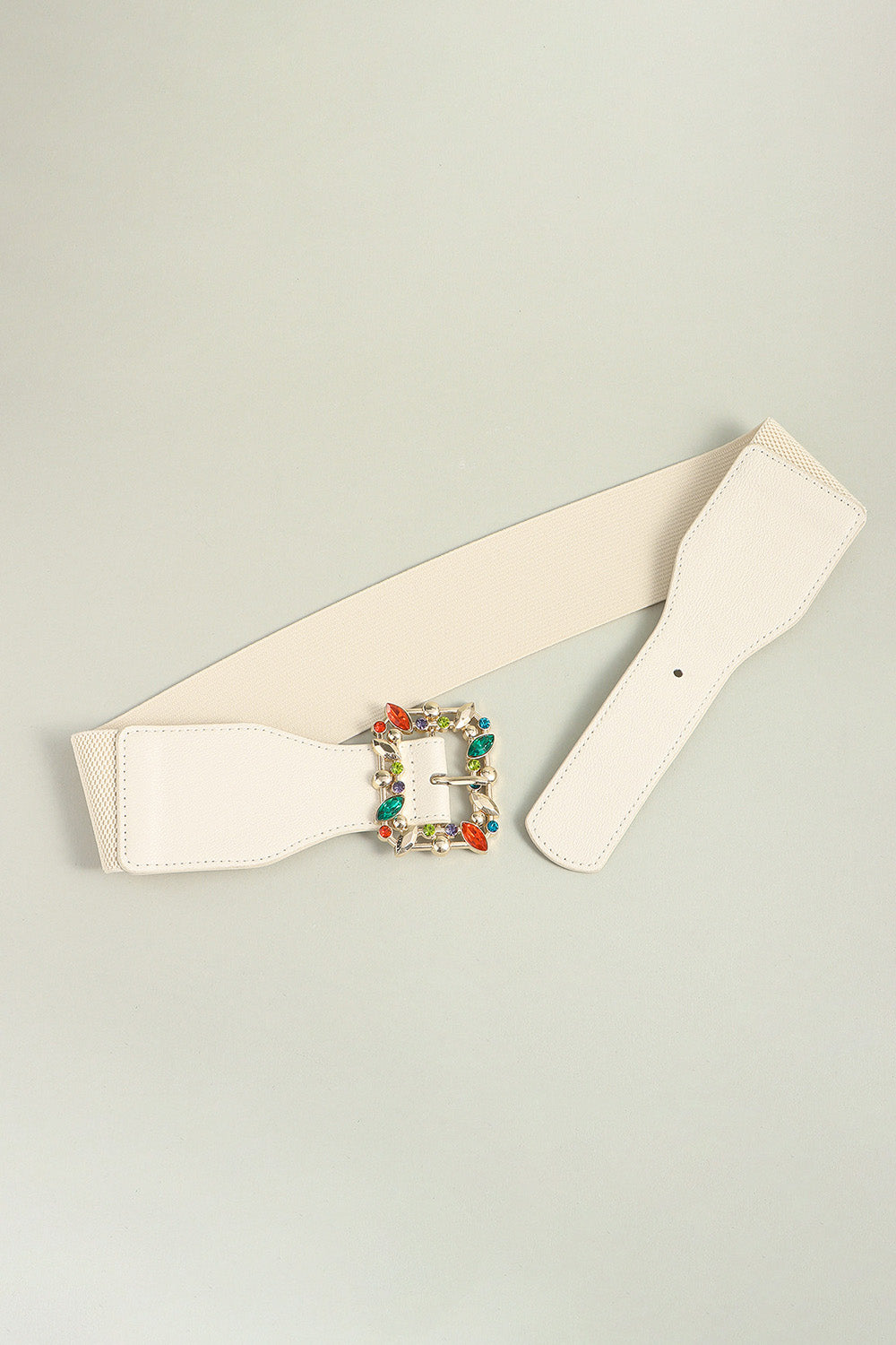 Ivory elastic belt laid flat with multicolor leaf buckle centerpiece