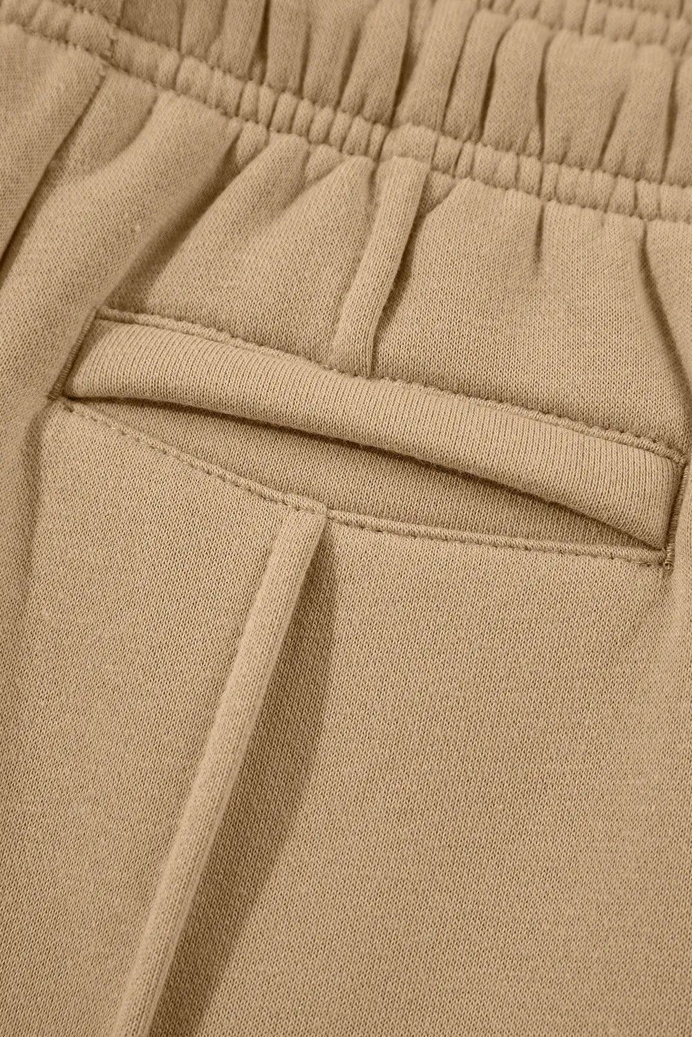 Tan pocket detail with stitched welt seam and elastic waistband lining