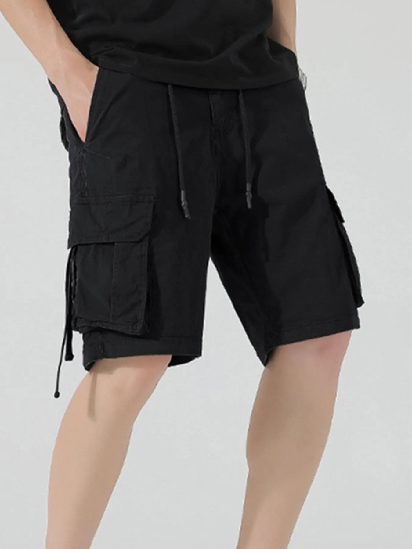 Men's black drawstring cargo shorts with side cargo flap pocket and tie cords