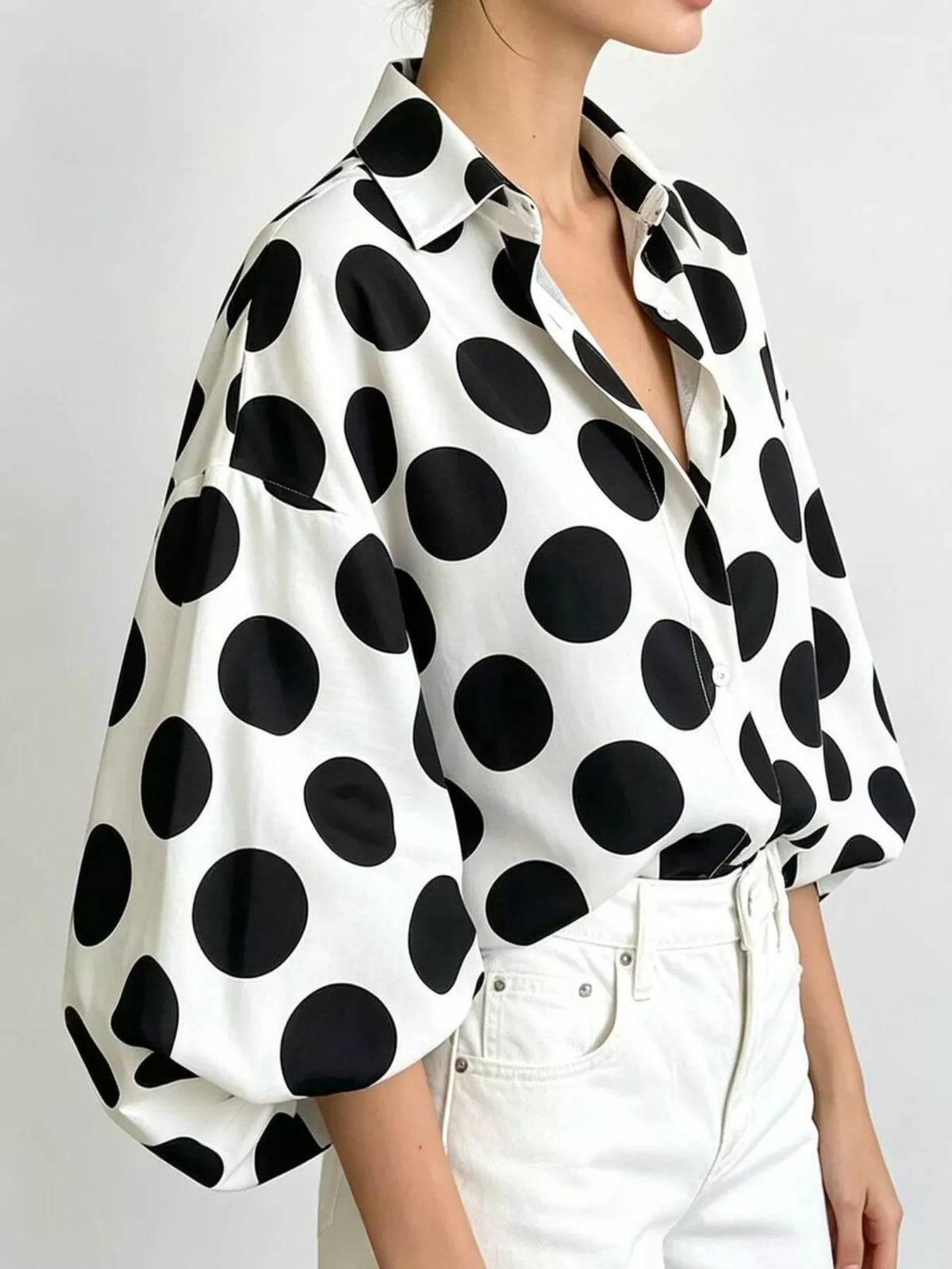 White polka dot button-front shirt with wide puff sleeves and pointed collar