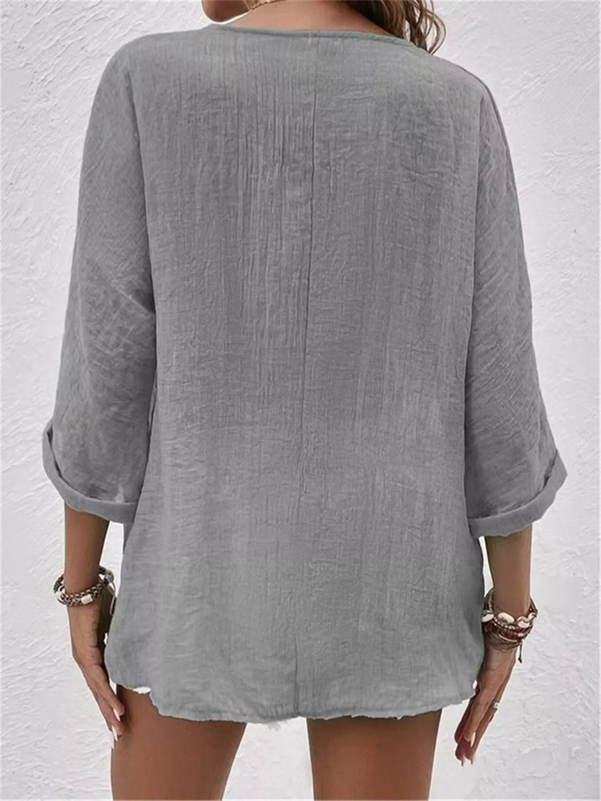 Back view of grey V-neck button blouse with 3/4 sleeves and relaxed fit