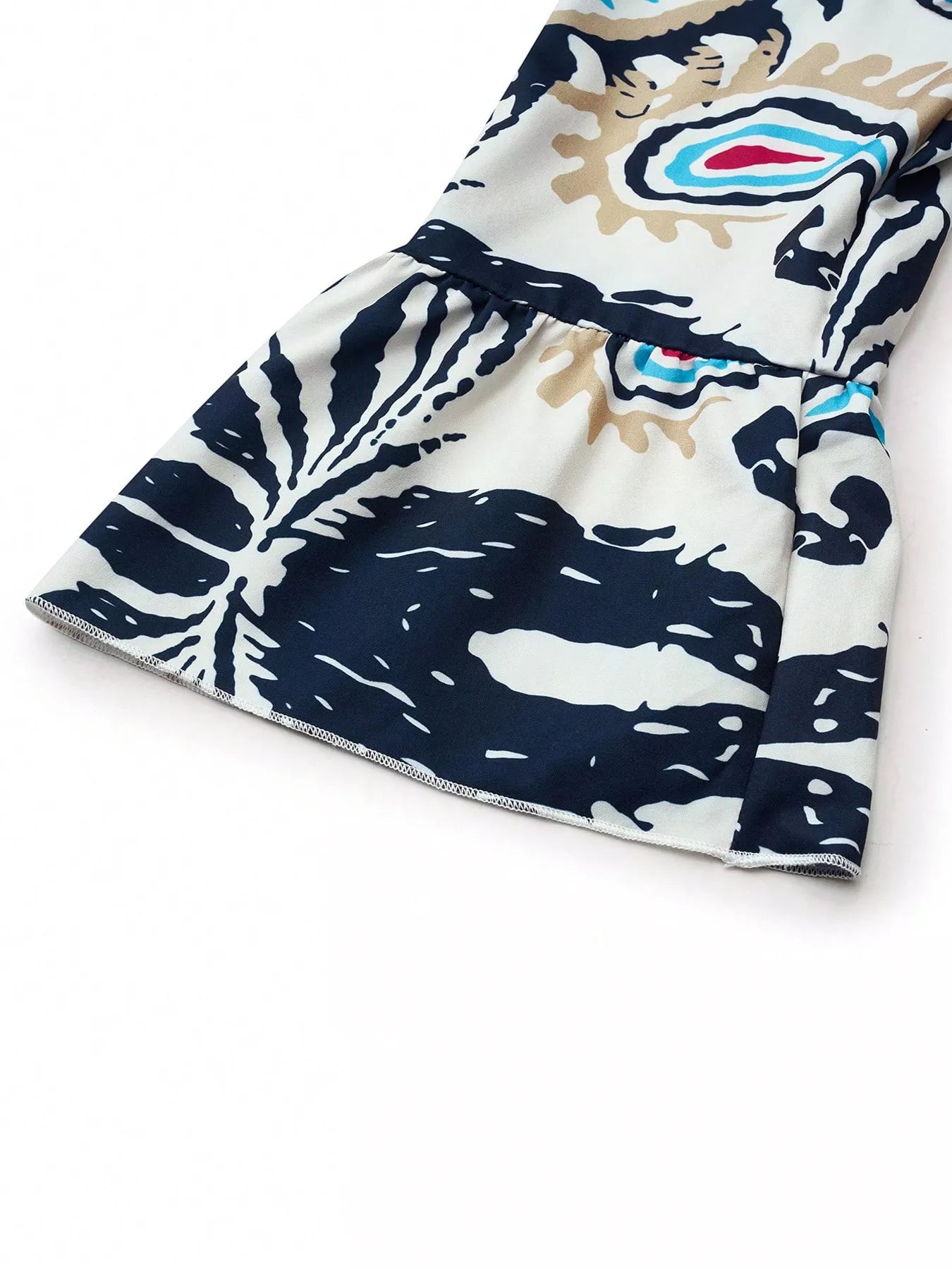 Bohemian print tiered mini dress fabric detail, navy-blue motifs on white, flared sleeve hem