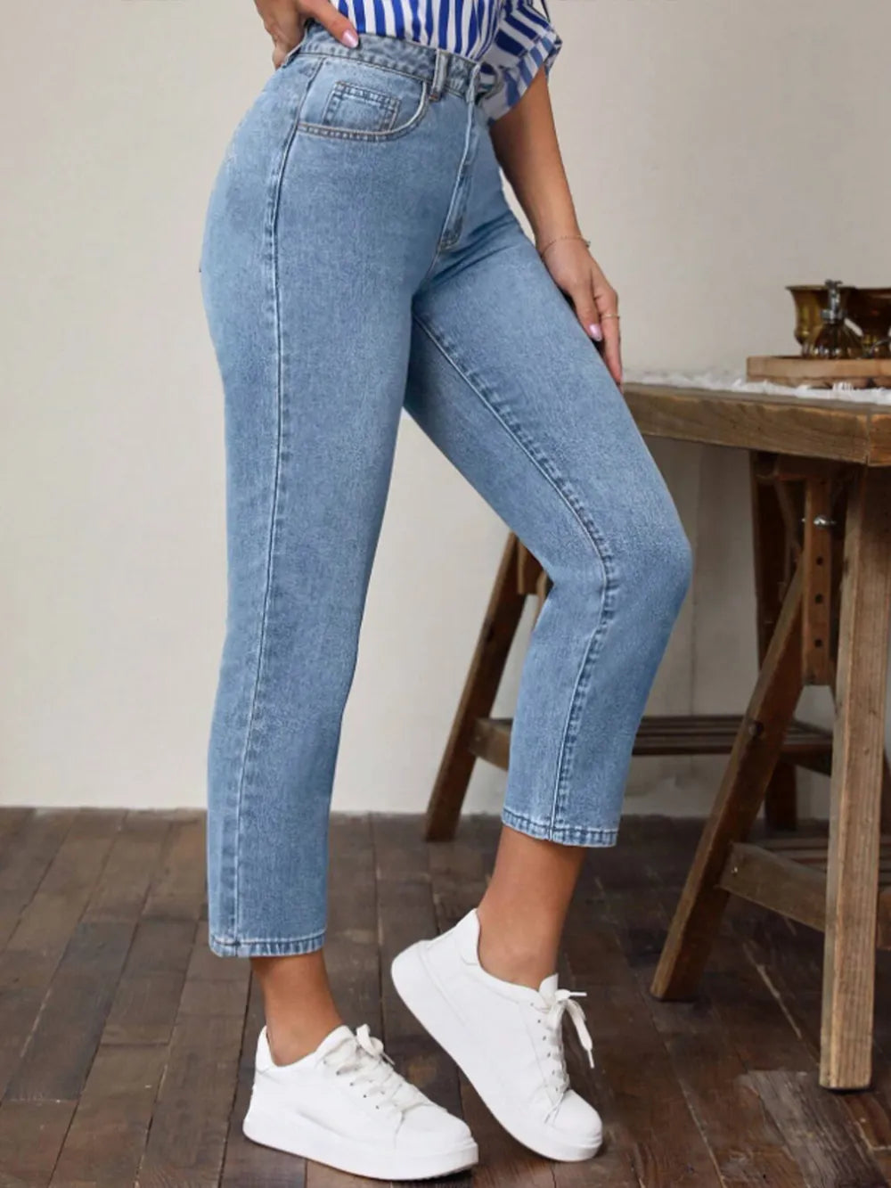 Light blue high-waist jeans with pockets, front side view, ankle-length slim fit